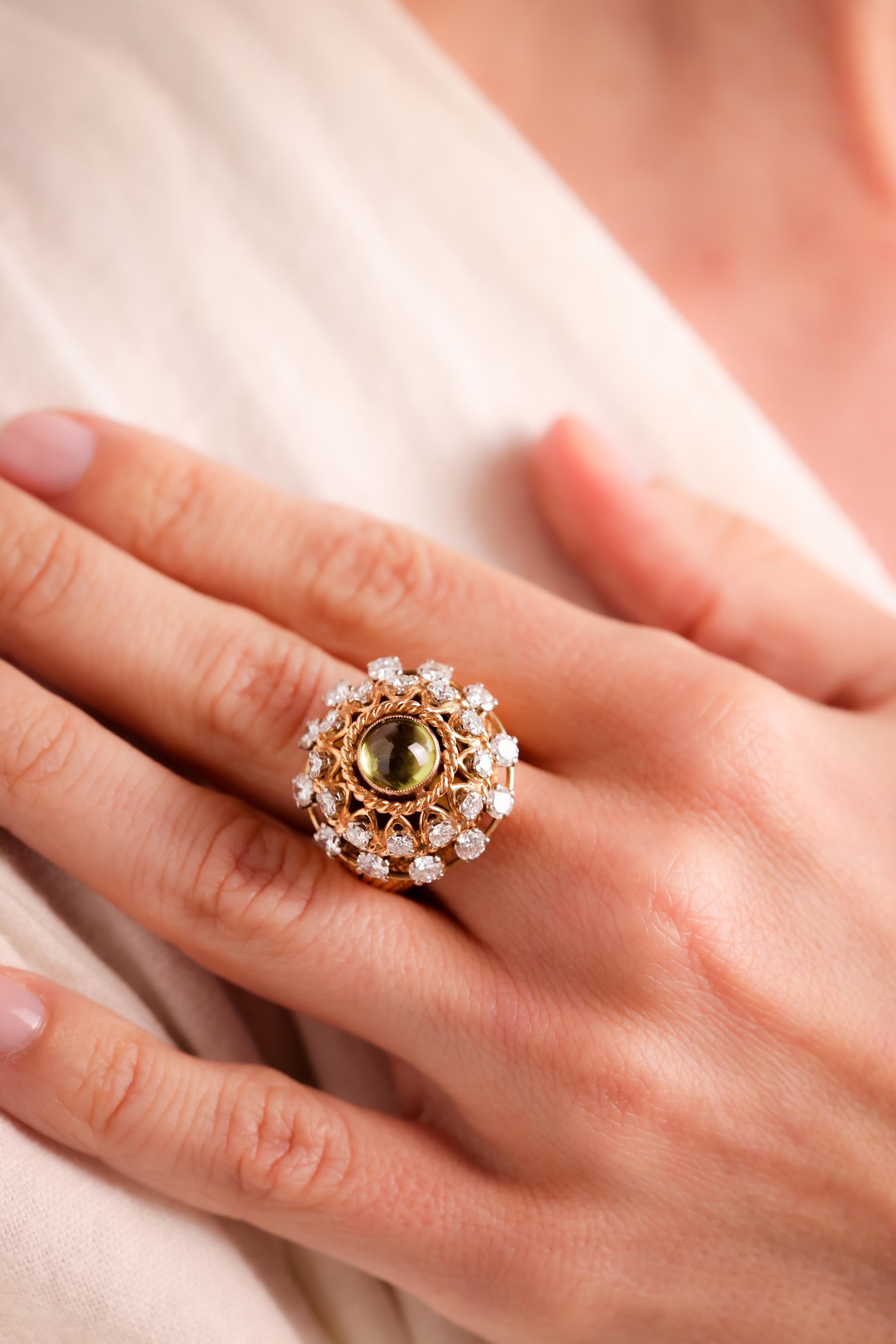Center Stone: Peridot
Cut: Cabochon Cut
Weight: Approximately 1.5 Carats
Color: Green
Accent Stone: 24 Diamonds
Cut: Round Brilliant
Weight: Approximately 2.5 Carats
Color: G
Clarity: VS
Metal: 18K Yellow Gold
Era: Mid-Century
Circa: 1960s
Size: 5