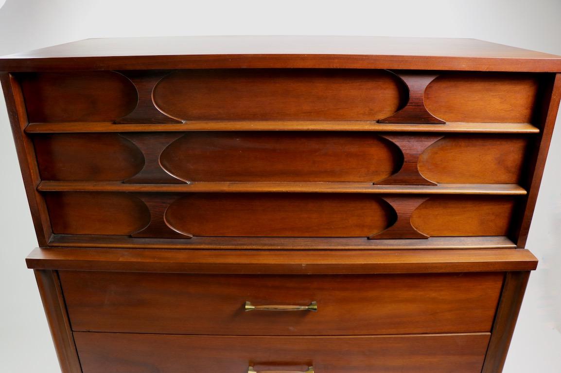 Stylish Perspecta high chest by Kent - Coffey in clean, original condition. This example features two drawers over three drawers, top drawers having rosewood bowtie pulls, lower drawers having elongated rosewood and brass pulls. Nice deep drawers