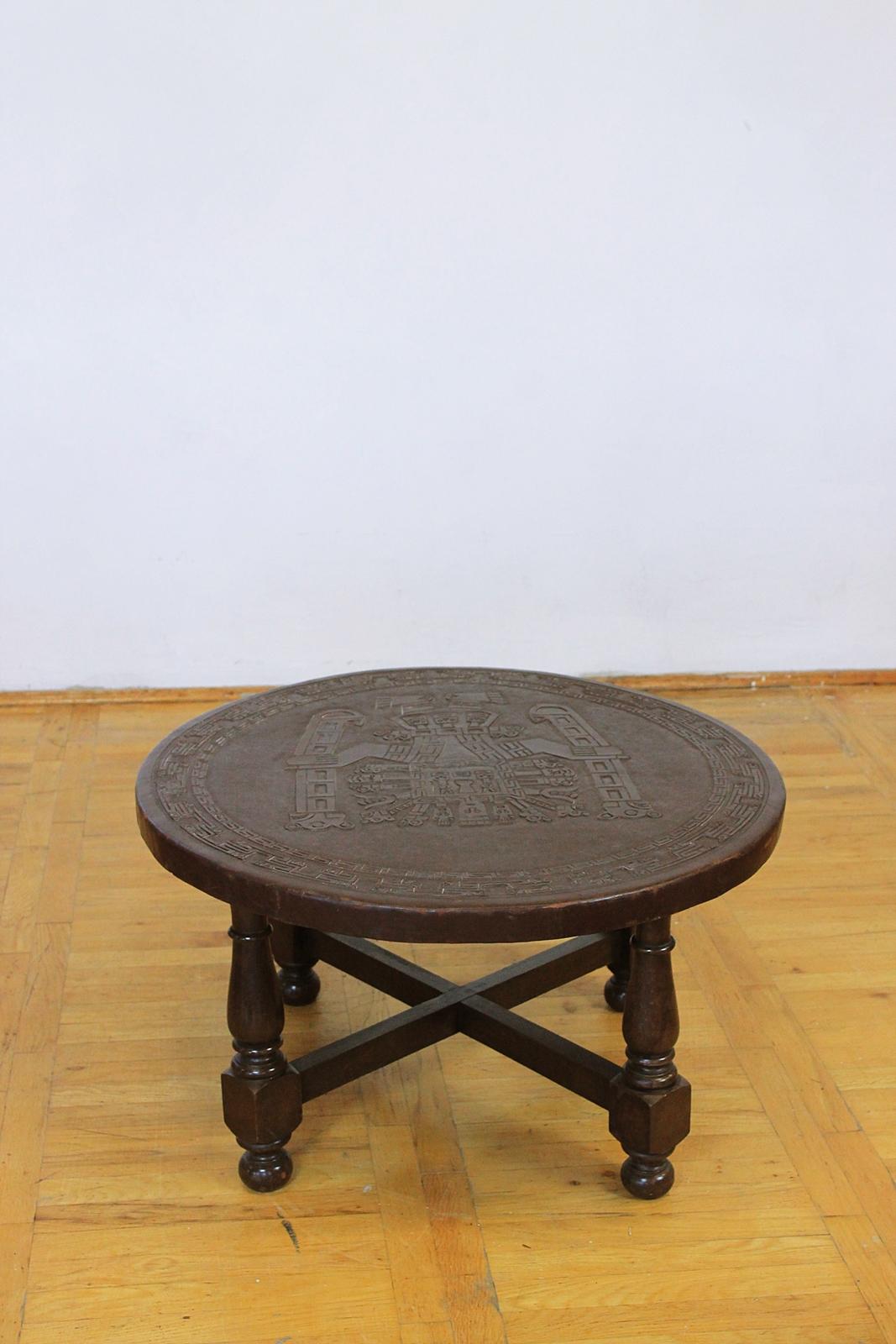 Vintage midcentury coffee table with Aztec motif on the leather top. Designed in the style of Angel Pazmino. Handmade construction in good vintage condition. The leather top has signs of wear.