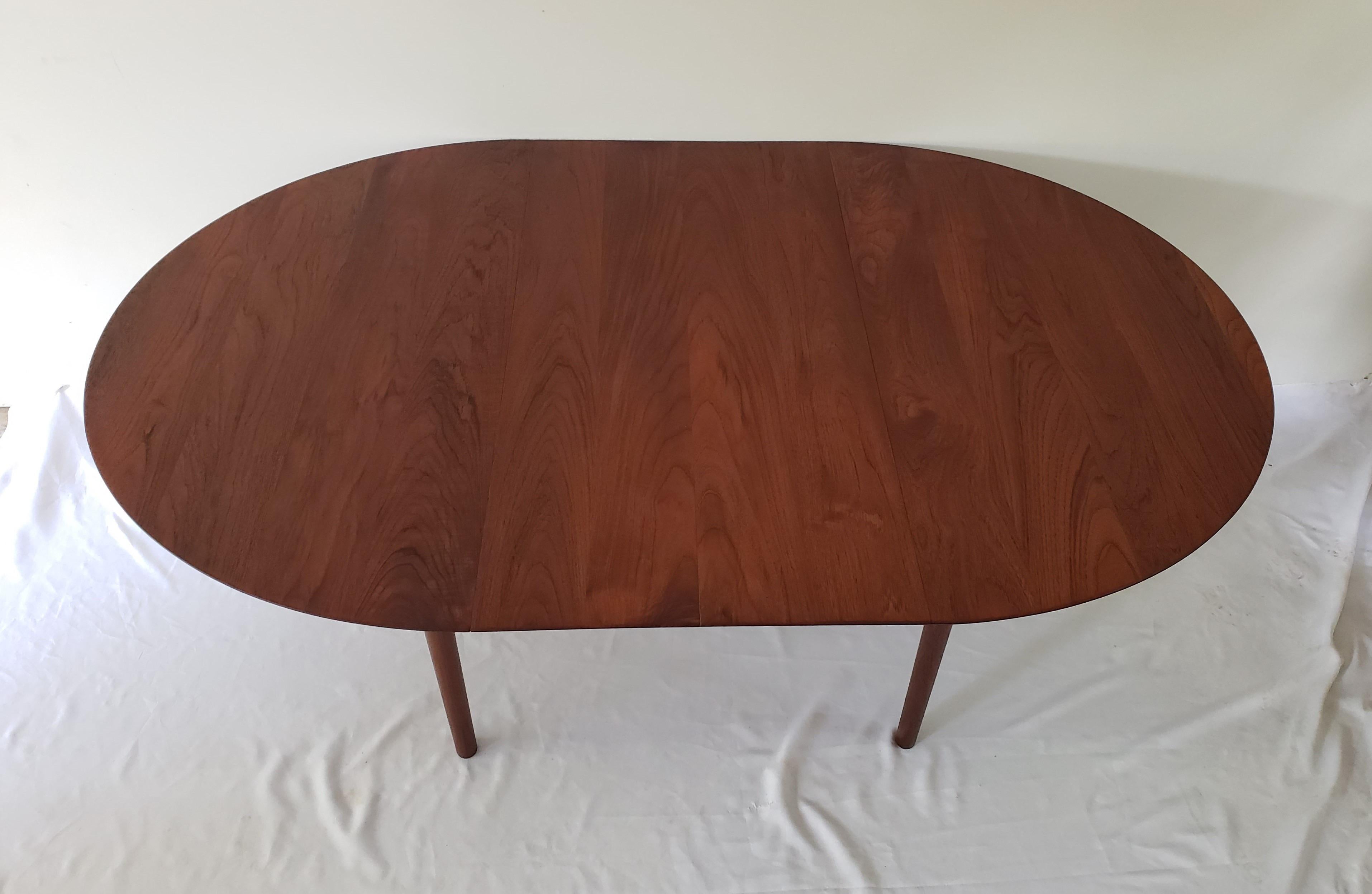 Peter Hvidt & Orla Mølgaard Nielsen model “311” Danish teak extendable dining table. Produced in Denmark by Søborg Møbler during the 1950s. Slightly oval solid teak tabletop with tapered conical teak legs. A great size for a smaller dining room or