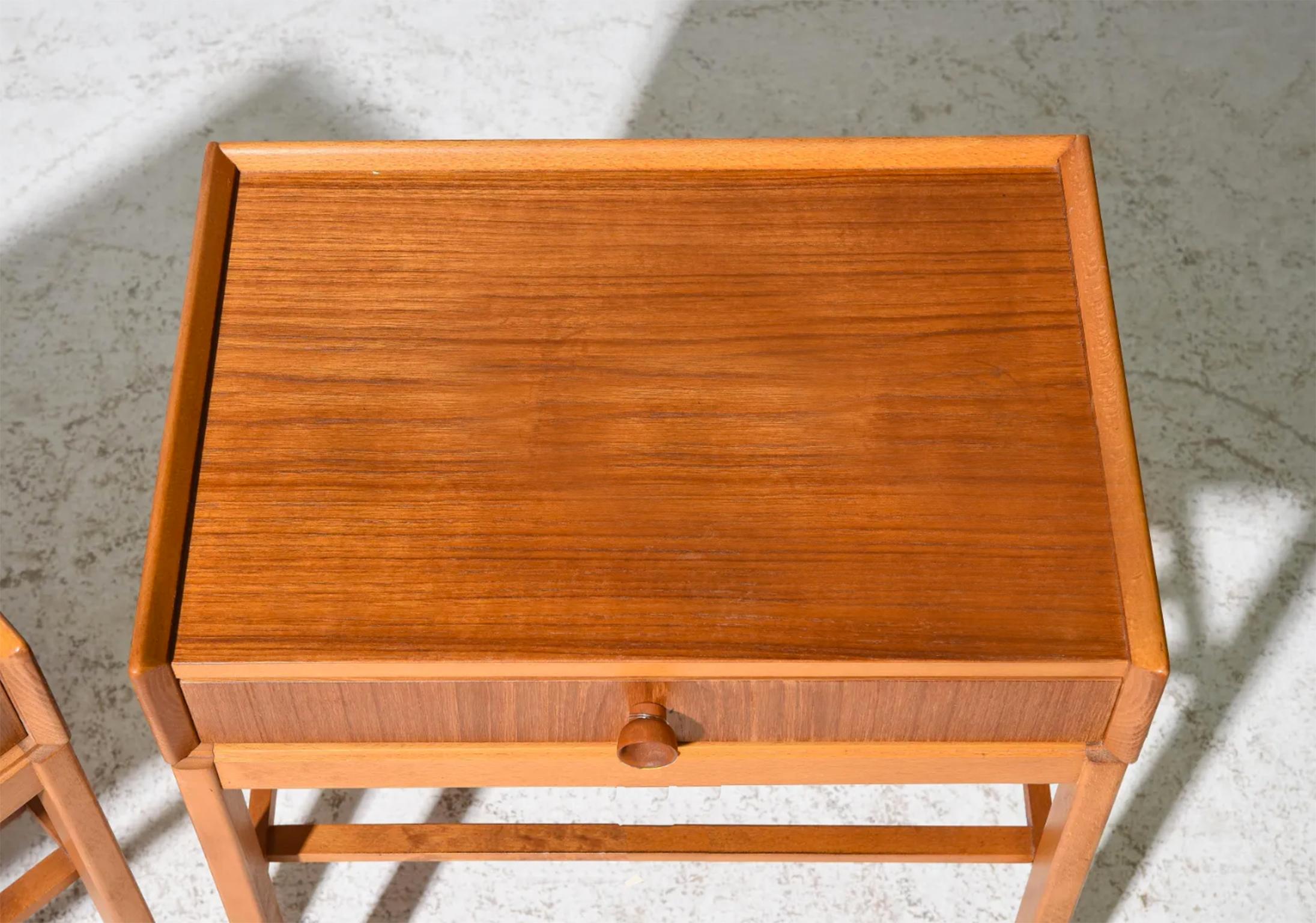 Beautiful pair of Danish modern petite teak nightstands lamp tables with single drawer Minimalist. Very clean set of rare nightstands. Simple delicate design with tapered knob lower slatted shelf as well as a lipped top surface, all solid teak. You