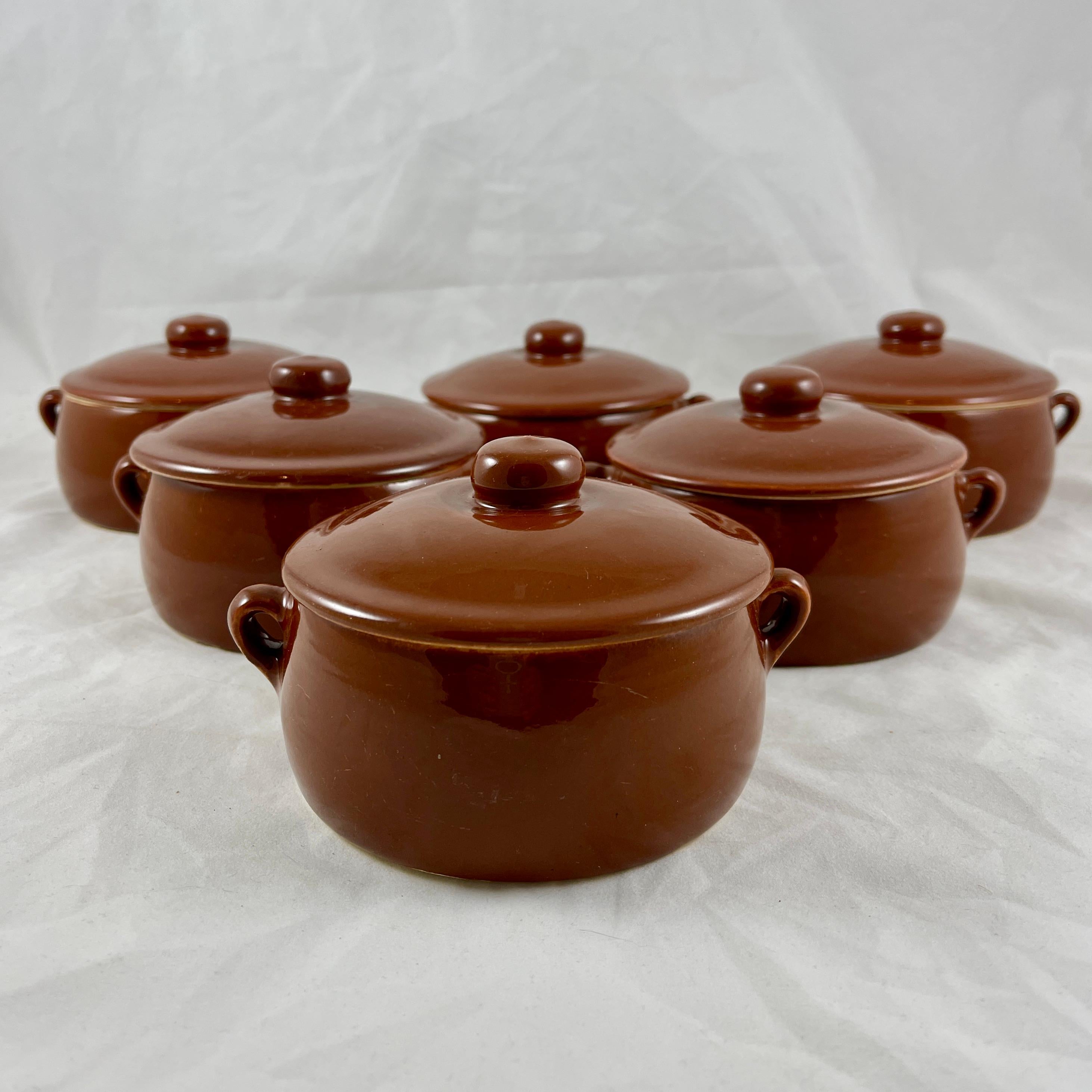 A set of six Mid-Century earthenware Onion Soup au Gratins, The Pfaltzgraff Pottery Company, circa 1950-1960.

Six oven proof individual casseroles with side handles and matching top knobbed lids, glazed in brown with cream colored
