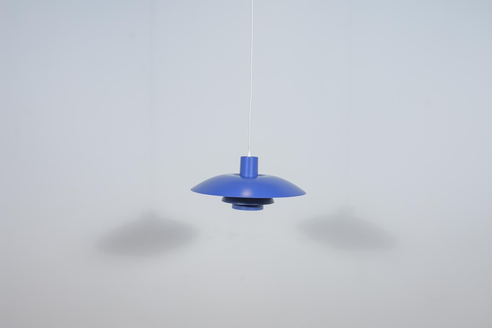 This pendant was designed by Poul Henningsen and produced by Louis Poulsen from 1966 until it was discontinued in this color in the late 1970s to early 1980s. It is made of powder-coated aluminum and is lit both downwards and from the sides. The PH