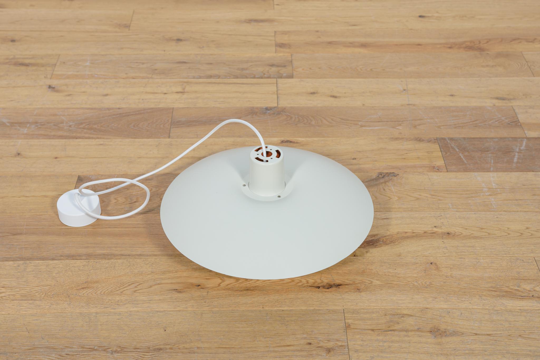 This pendant was designed by Poul Henningsen and produced by Louis Poulsen from 1966 until it was discontinued in this color in the late 1970s to early 1980s. It is made of powder-coated aluminum and is lit both downwards and from the sides. The PH