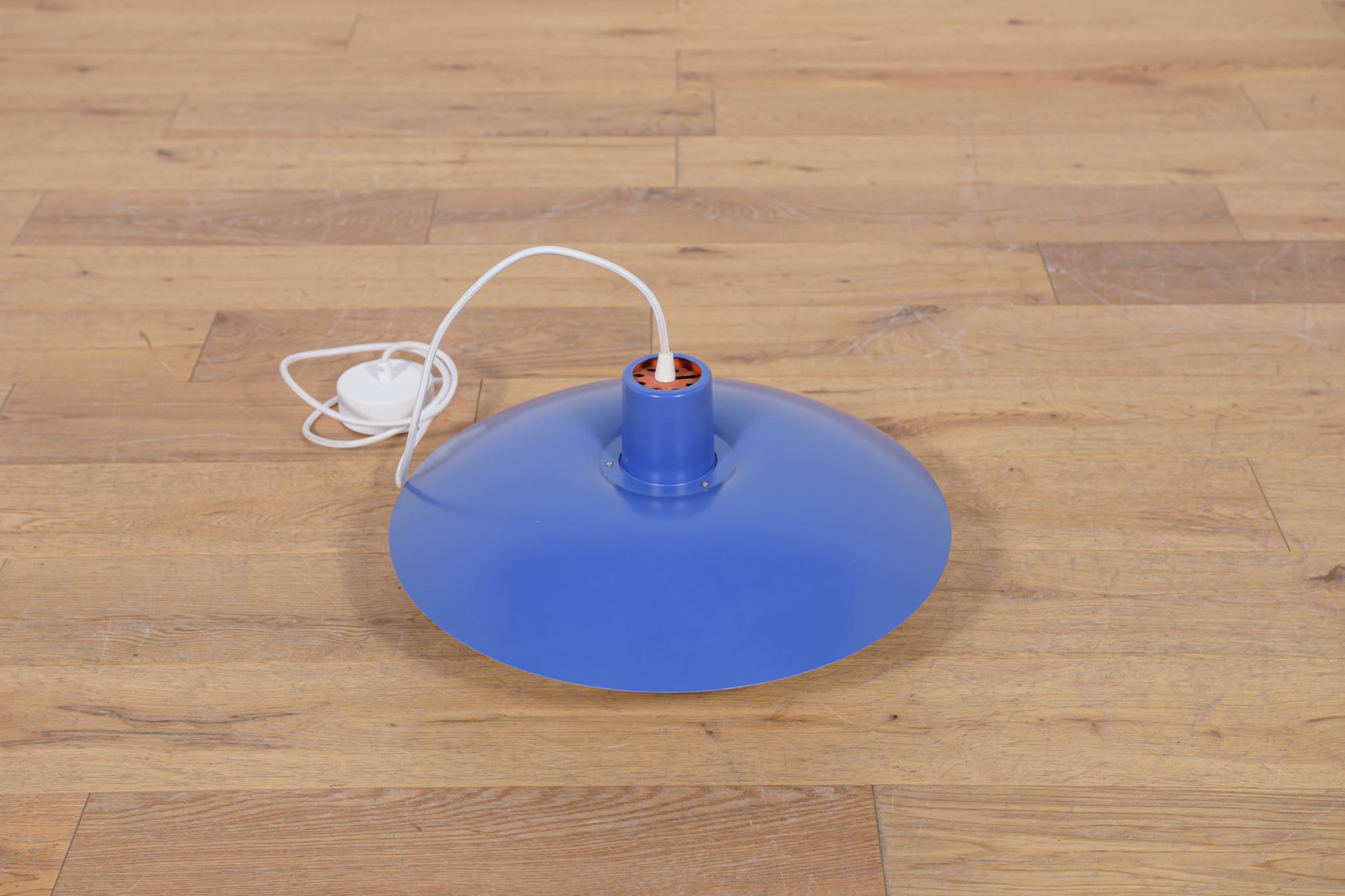 This pendant was designed by Poul Henningsen and produced by Louis Poulsen from 1966 until it was discontinued in this color in the late 1970s to early 1980s. It is made of powder-coated aluminum and is lit both downwards and from the sides. The PH