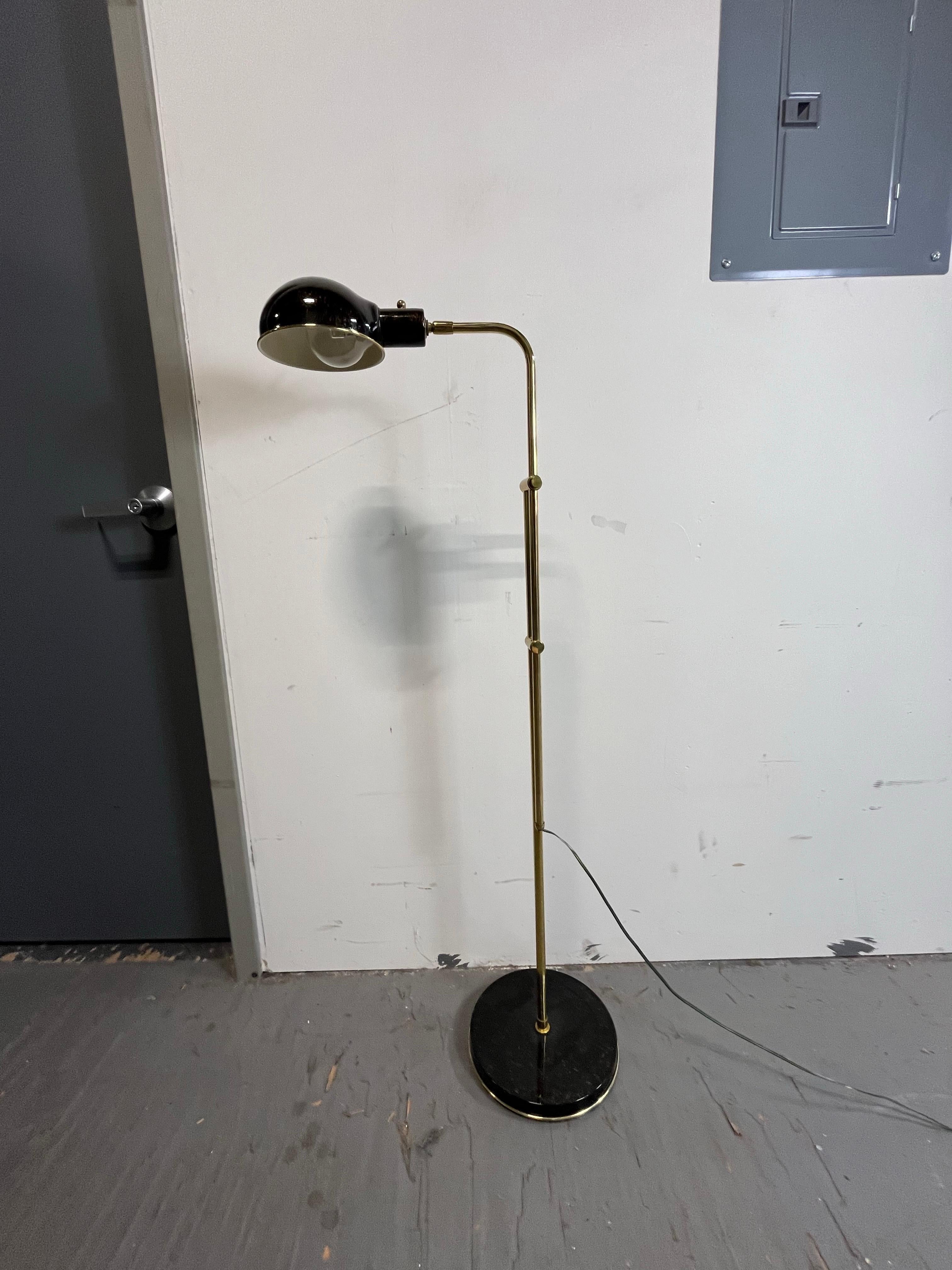 Lampadaire réglable unique de la pharmacie du milieu du siècle. L'abat-jour en forme de dôme pivote et s'oriente. Superbe finition en faux bronze sur le dôme et la base. Tube et quincaillerie en laiton. Entièrement déployé, il mesure 57,5