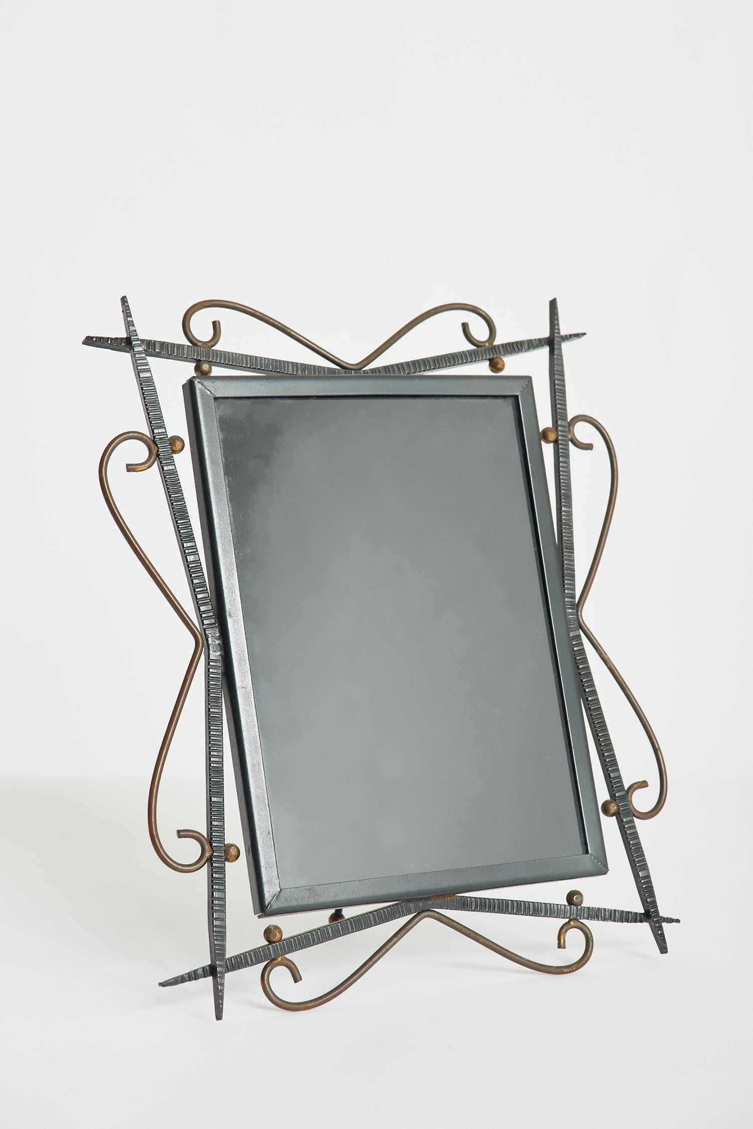 A black enamelled iron and brass photo frame.
France, 1950s.