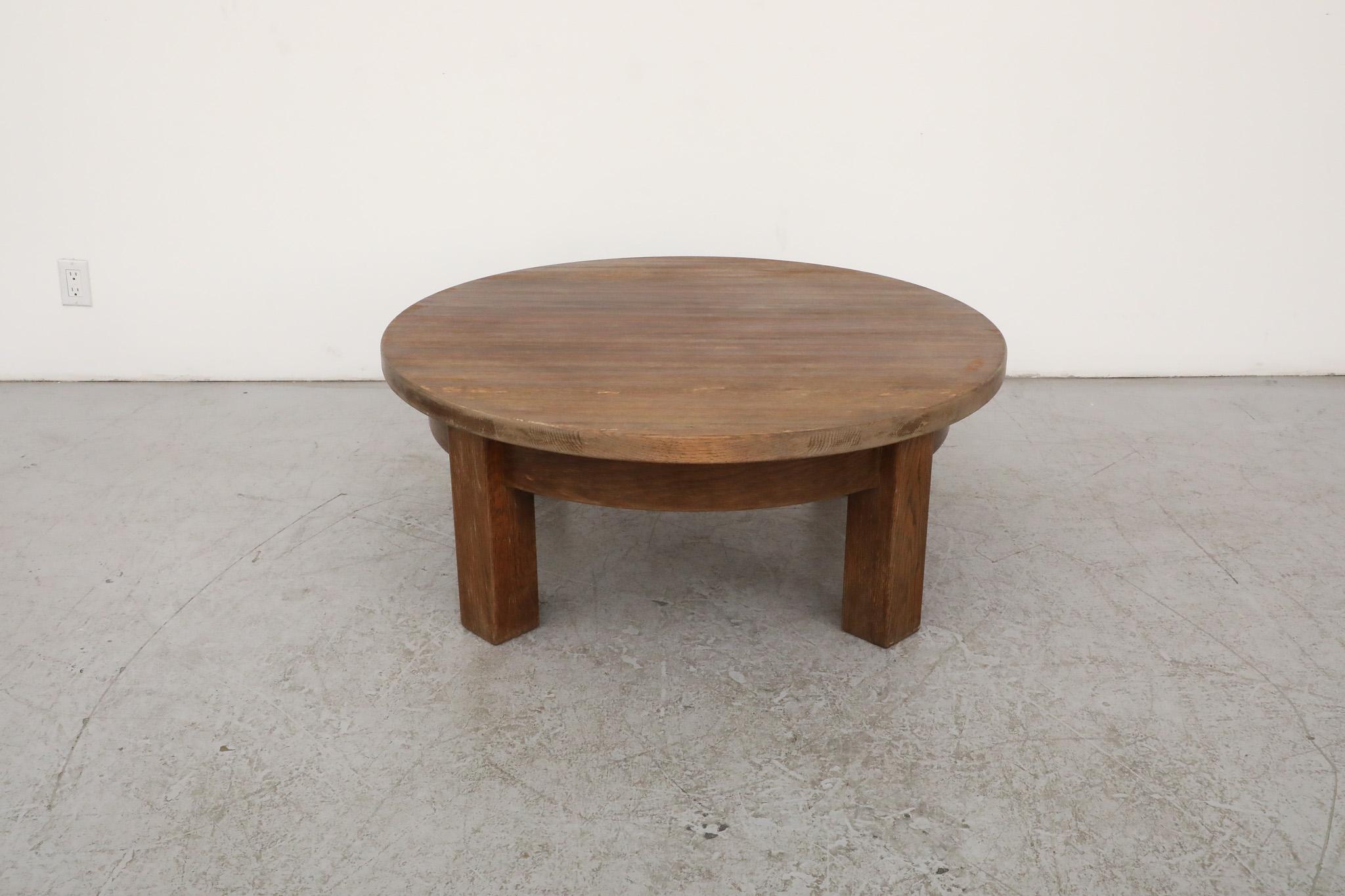 This Mid-Century, Brutalist coffee or side table is expertly made from dark stained solid oak and outfitted with a round top and four rustic and sturdy legs. Inspired by the ground breaking designs by French Mid-Century pioneer Pierre Chapo this