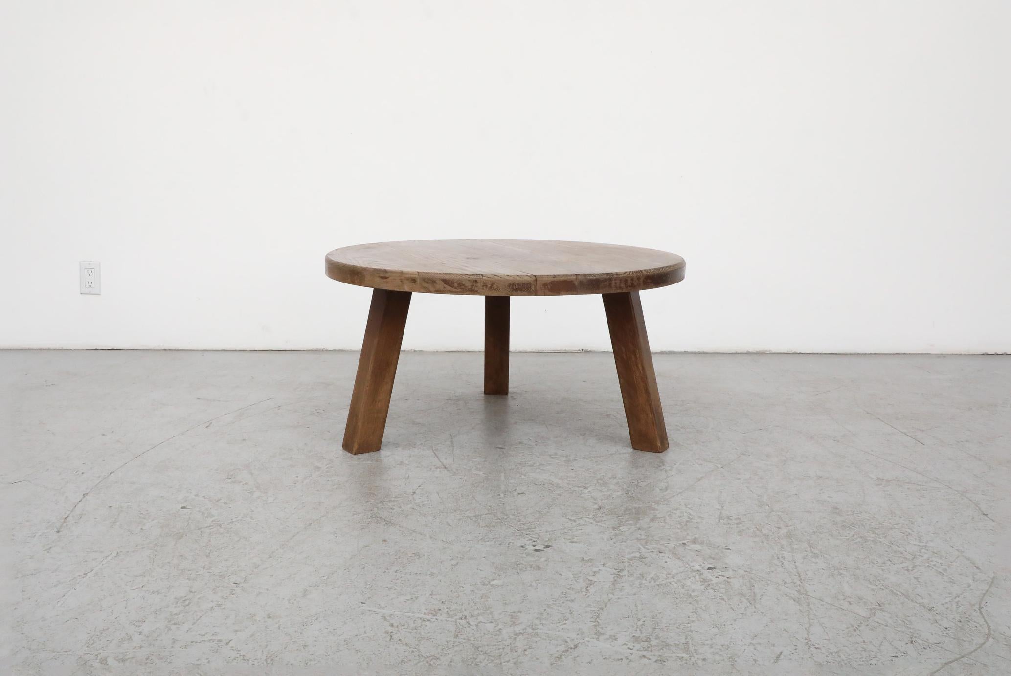 Mid-Century, Brutalist Pierre Chapo style coffee table. Made from solid, well aged oak, with a generous, round top and tripod legs. In original condition with visible wear, including some natural cracking. Wear is consistent with its age and use.