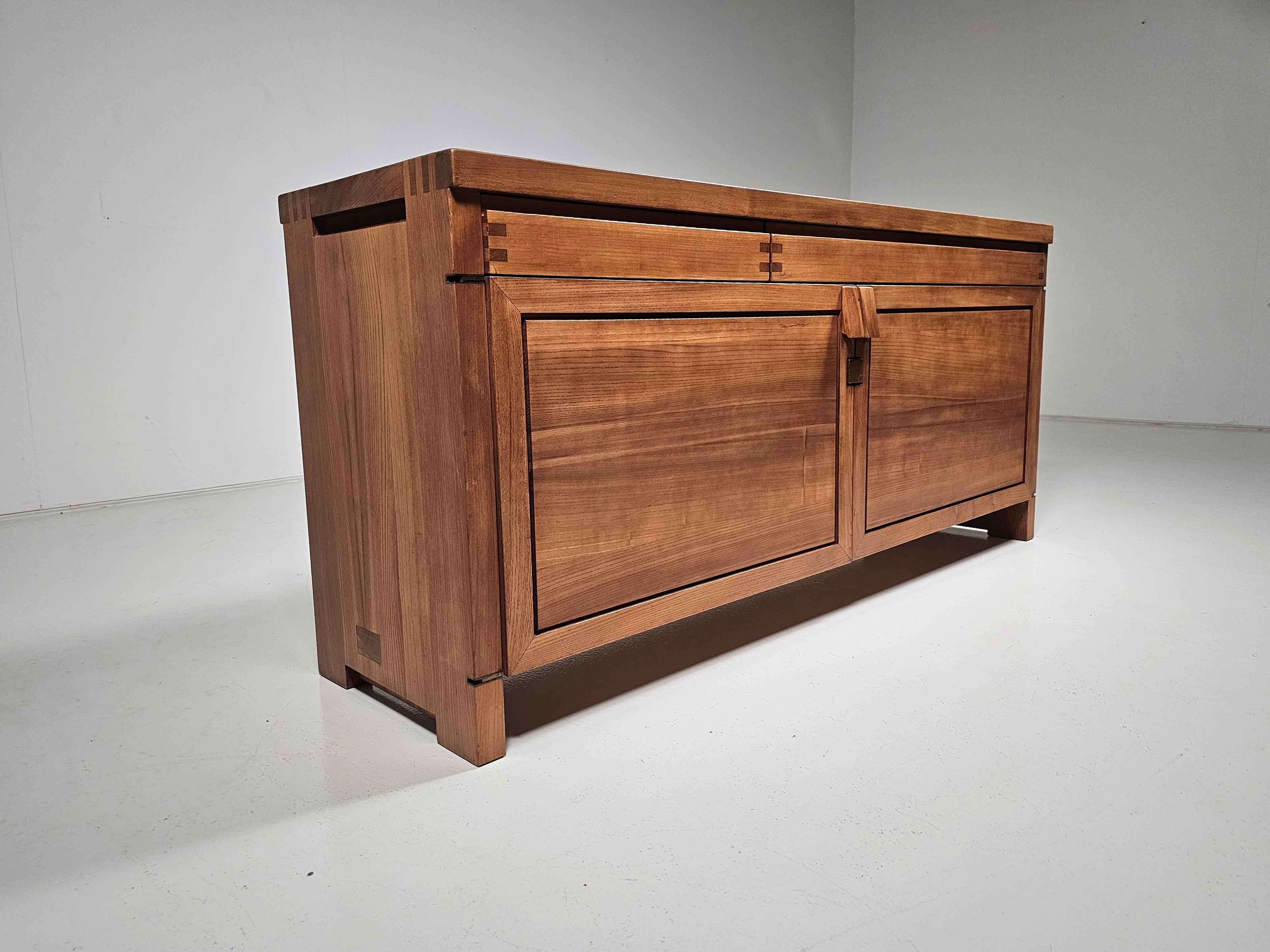 Pierre Chapo, sideboard, Model R08, elm, France, circa 1964.

This stunning credenza combines a simplified yet complex design with nifty, solid construction details that characterize Chapo's work. The well-proportioned doors and drawers are
