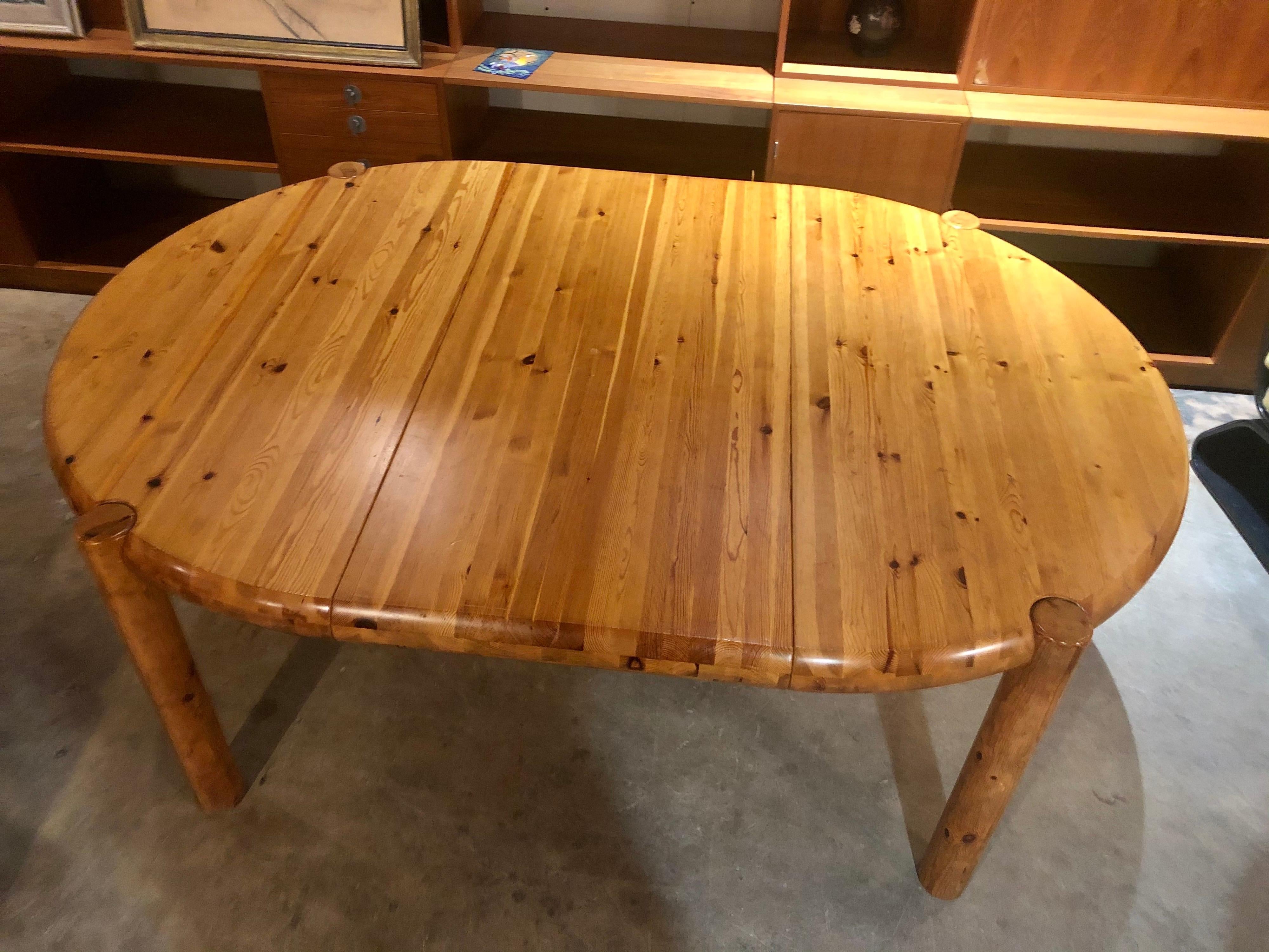 Mid-century Danish extendable dining table by Rainer Daumiller is pine and has a curved form. Pine legs offer the same curve and is thick. This vintage dining table is in good condition.