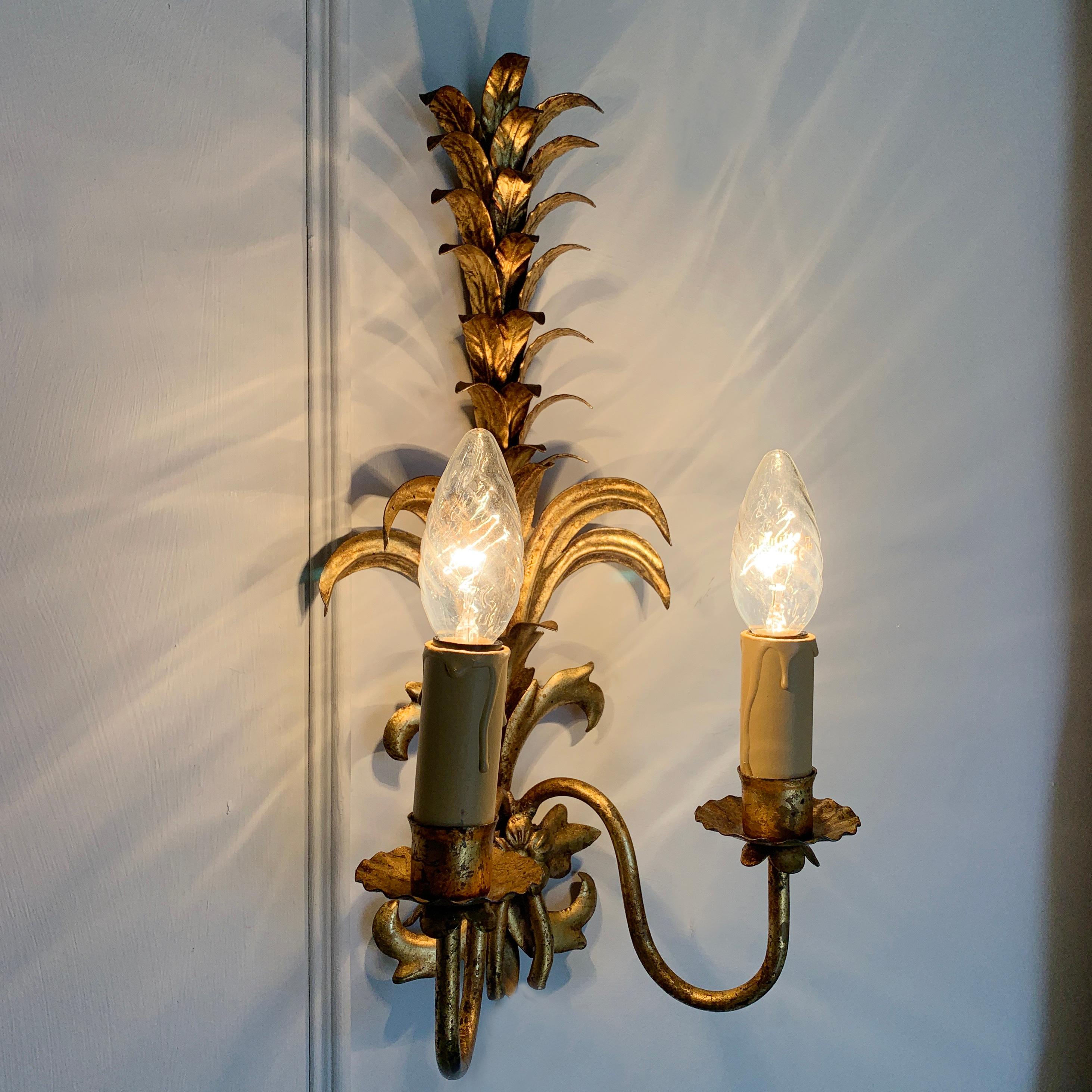 Une belle paire d'appliques en fronde d'ananas dorées. Français, datant des années 1950, il présente des détails complexes et une étonnante finition dorée naturaliste.

Chacune des lampes en métal doré est munie de deux porte-lampes.

Petites