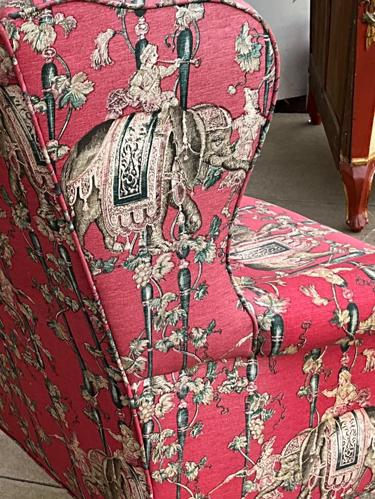 This is so fun! It is a wingback chair in a pink/deep magenta chinoiserie fabric. The frame is a fruitwood with ball and claw front feet. The fabric shows some wear. The chair is unmarked.