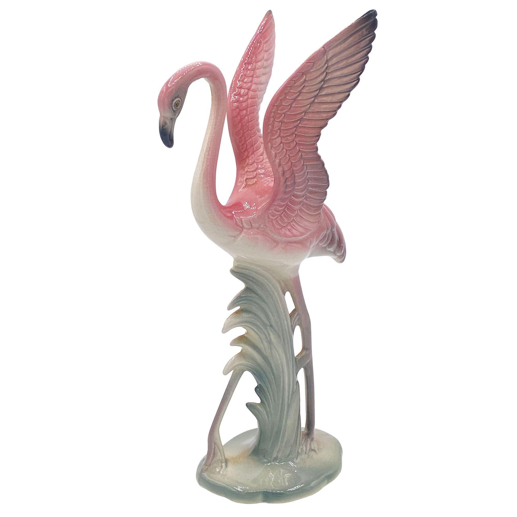Mid-century pink and green matching California Pottery ceramic flamingo tabletop statue pair by Brad Keeler. The set features two beautifully detailed pink flamingos in lush green leaves and grass with a pink color. The large statue features a