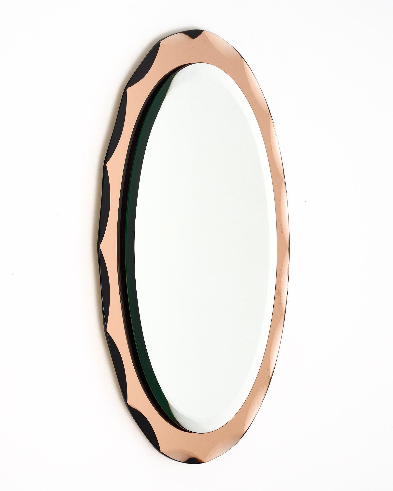 Mirror from mid-century Italy with a central oval beveled mirror and a pink mirror frame with scalloped edges. We are drawn to the detail. This piece would be perfect in an entry or feminine vanity space.
