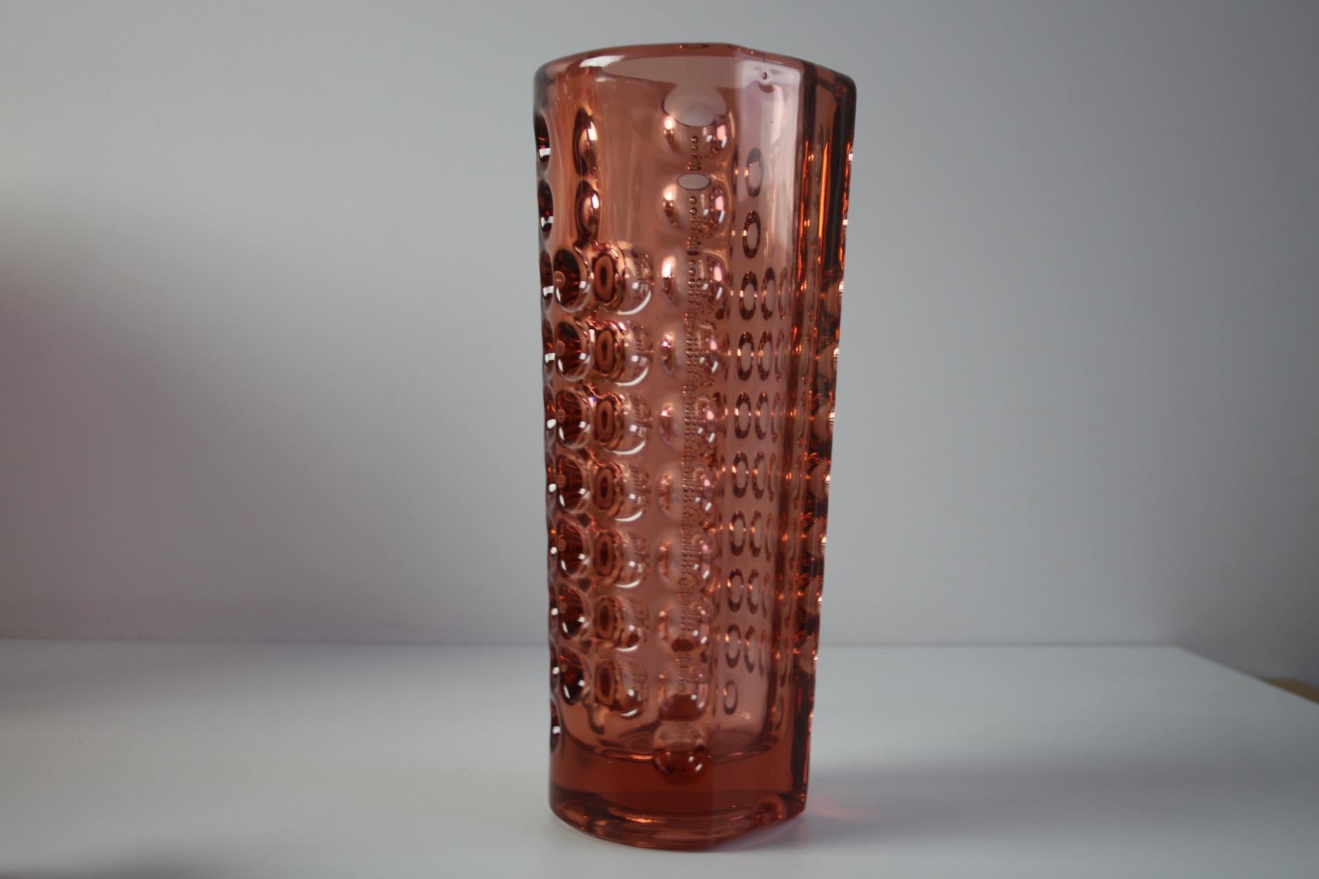 An exceptional mid-century modern pressed glass vase designed by Rudolf Jurnikl for Rudolfova Huť in 1960. This elegant cylindrical vase is crafted from softly tinted rosé pink pressed glass, featuring a repeating geometric pattern of indented