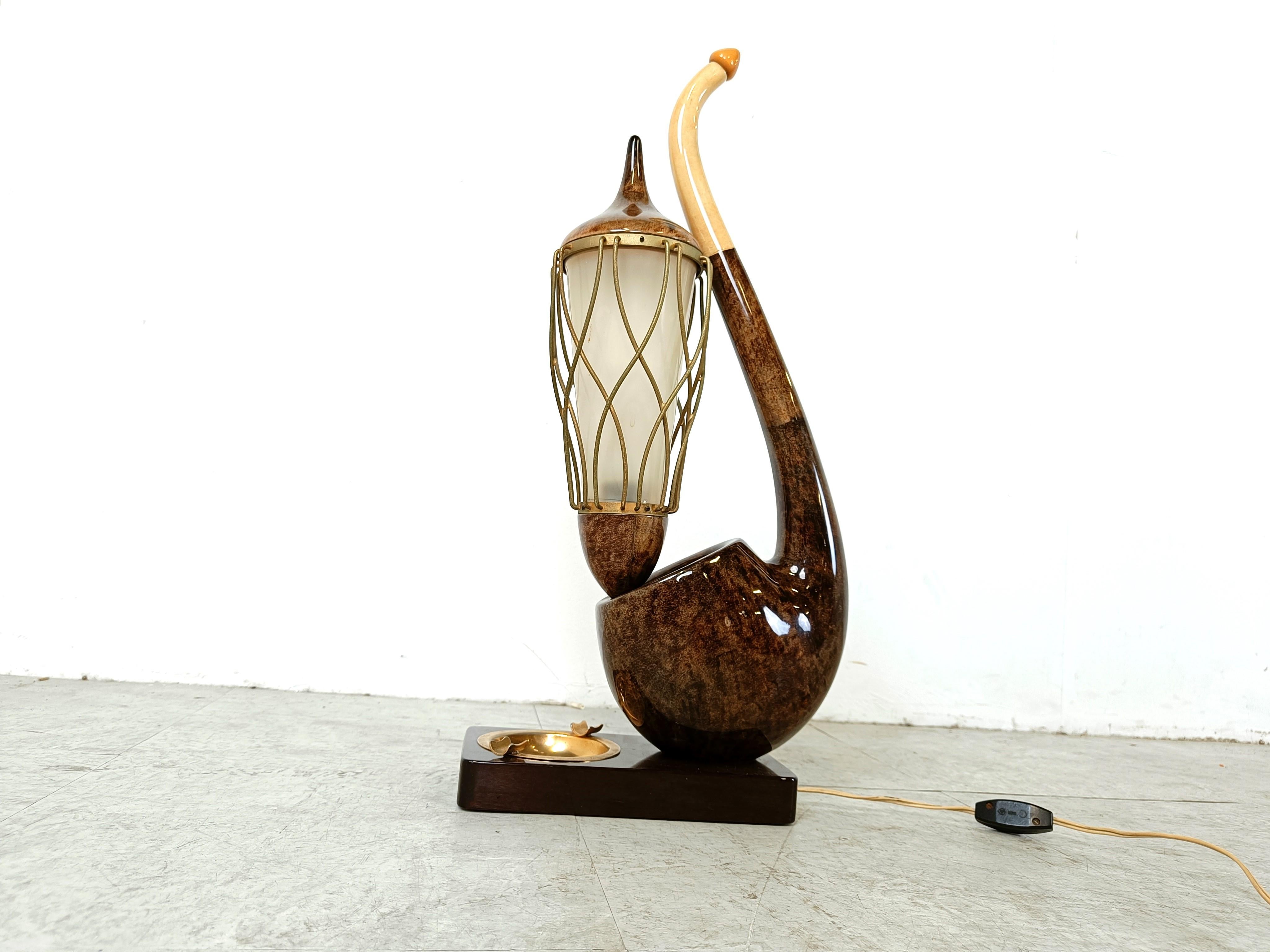 Rare mid century modern table lamp by Aldo Tura shaped like a pipe with a caged torch lamp and a plastic lamp shade.

it also has a brass ashtray embedded in the base of the lamp.

Made from beige and brown lacquered goatskin.

Labelled under the