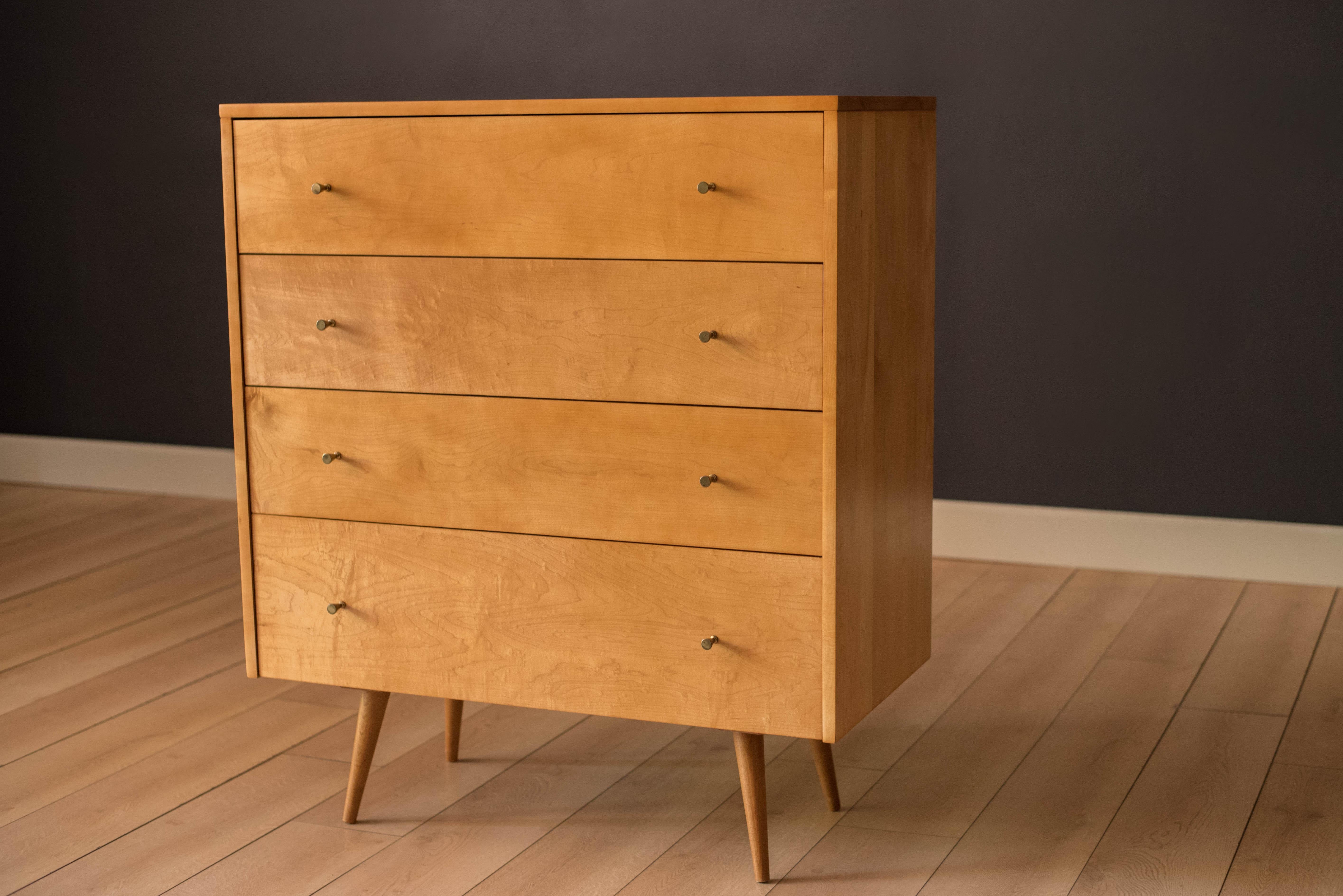 Vintage tall dresser chest in solid planked maple designed by Paul McCobb for Winchendon Furniture Co. circa 1950's. This piece offers plenty of storage including four deep drawers with the original signature brass hardware and splayed legs.