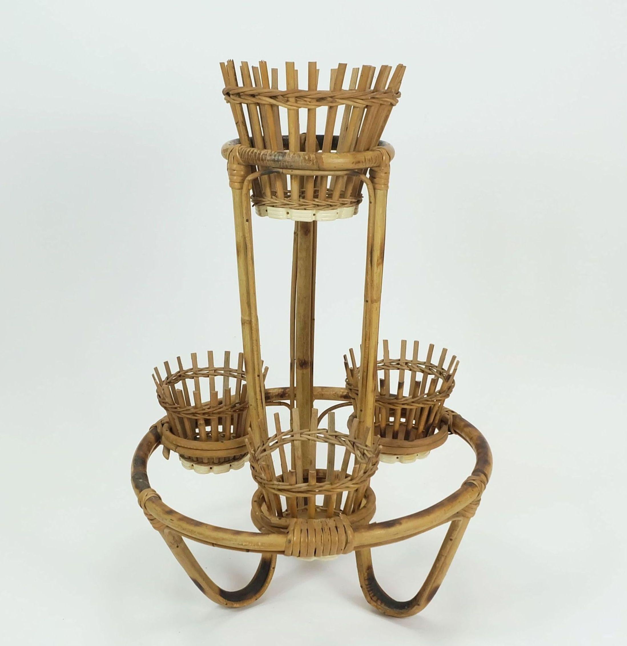 Portapiante molto bello e decorativo degli anni '50-'60. Realizzato in bambù e rattan. 4 inserti rimovibili. Gli inserti hanno una base in legno e sono rinforzati da un nastro di plastica bianco nella parte inferiore.

Dimensioni in cm:
Altezza 68