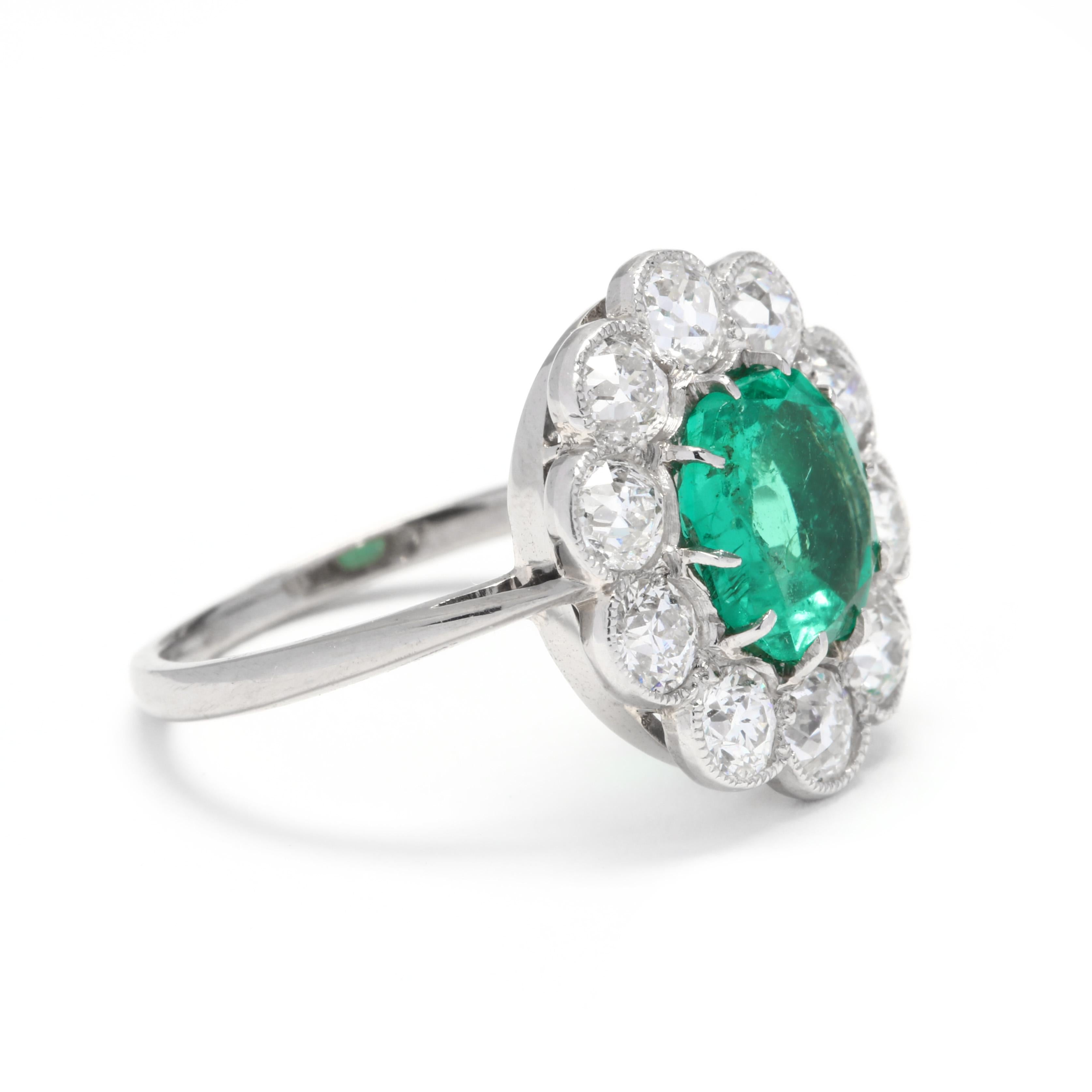 A mid-century platinum, emerald and diamond halo ring. This ring features a prong set, oval cut emerald weighing approximately .79 carat, with a bright, lively green color surrounded by a halo of old European cut diamonds weighing approximately 1.10