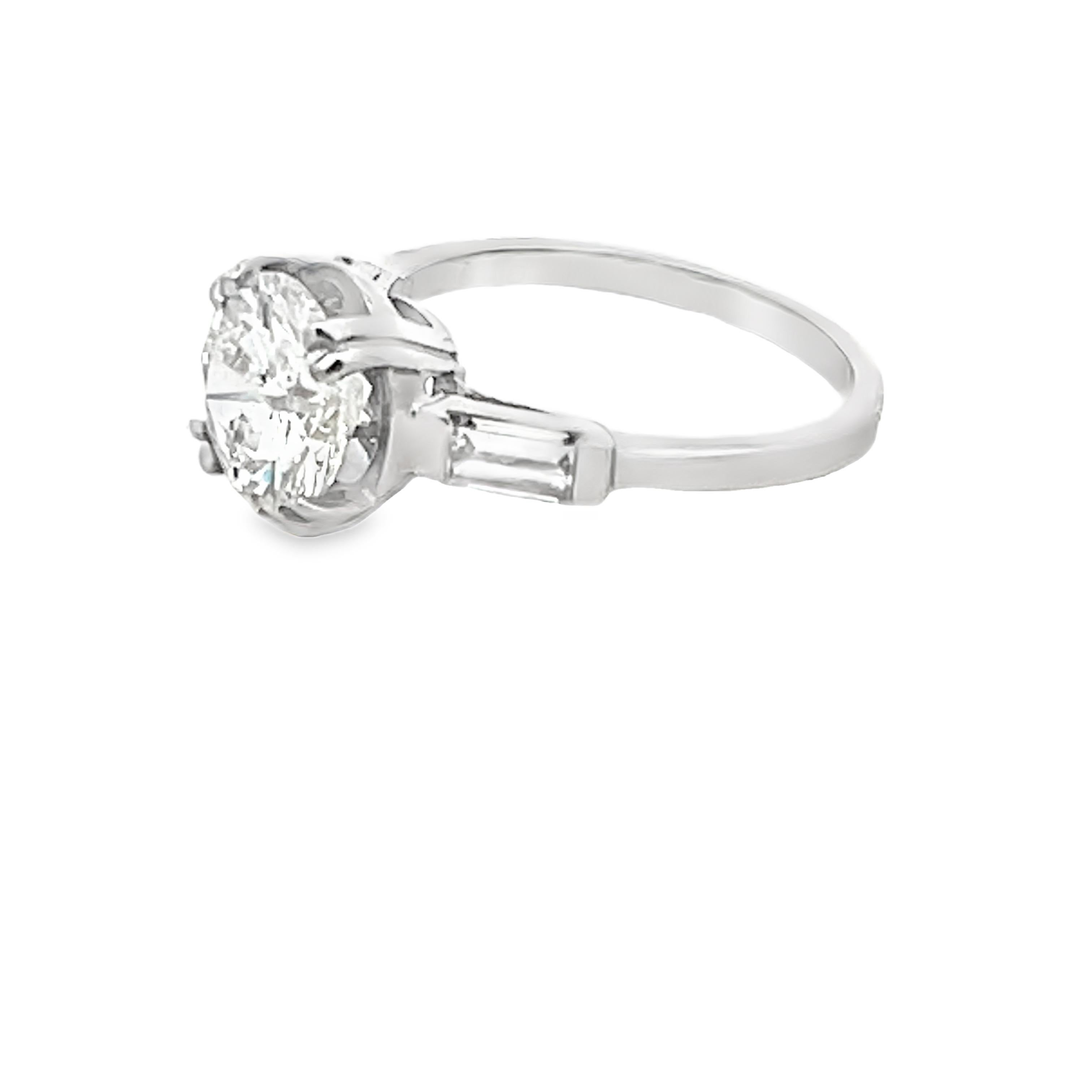 A stunning example of refined Mid-Century design, this elegant engagement ring is crafted in luxurious platinum and features a dazzling 2.50 carat round brilliant-cut center diamond, graded I color and SI2 clarity. The diamond is securely set in a