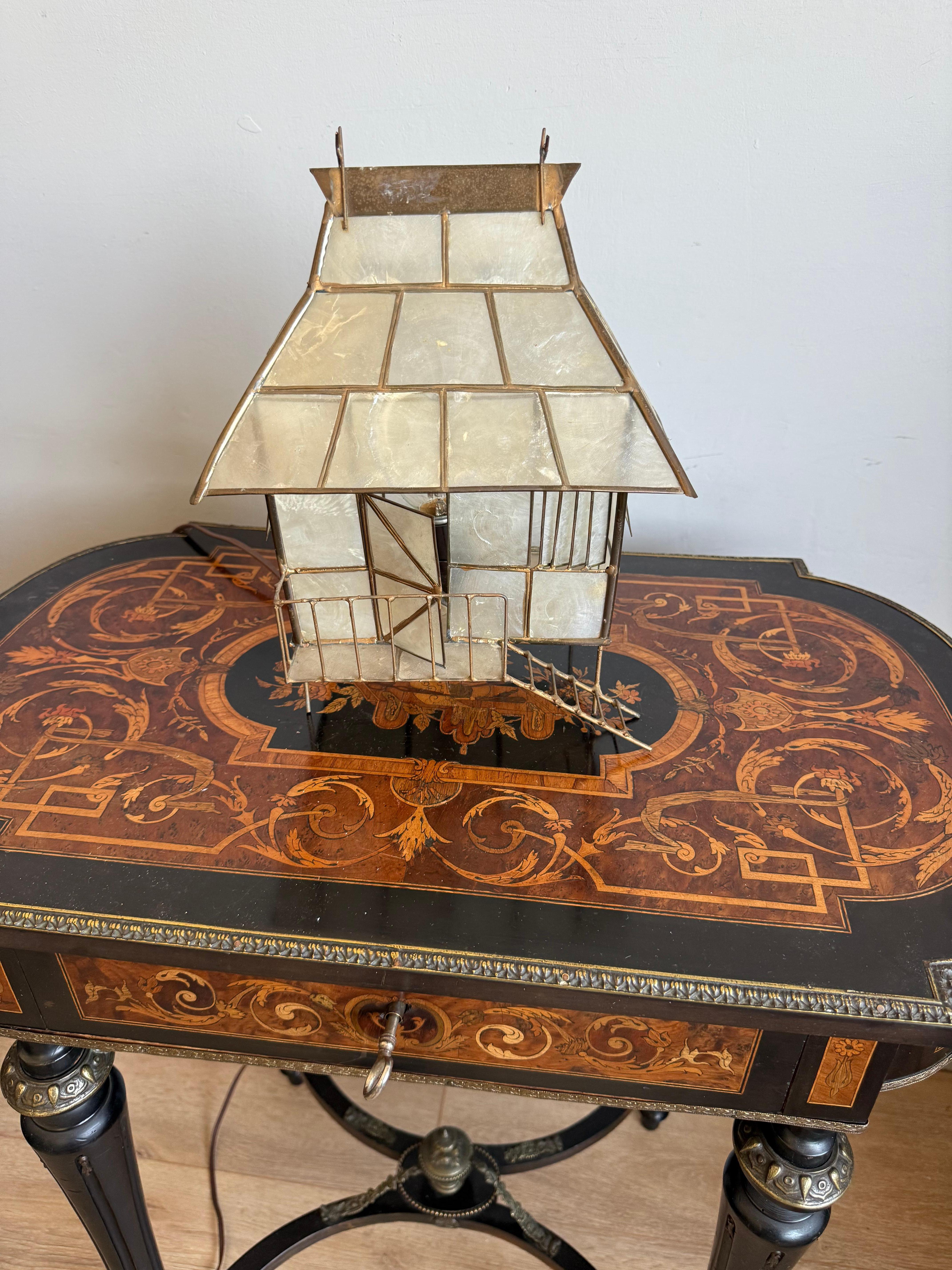 Rare hand-crafted miniature chalet table lamp.

This enchanting table lamp is a rare mid-century piece, handcrafted in the form of a miniature house. Constructed from delicate translucent faux glass panels set in a brass framework, the lamp features
