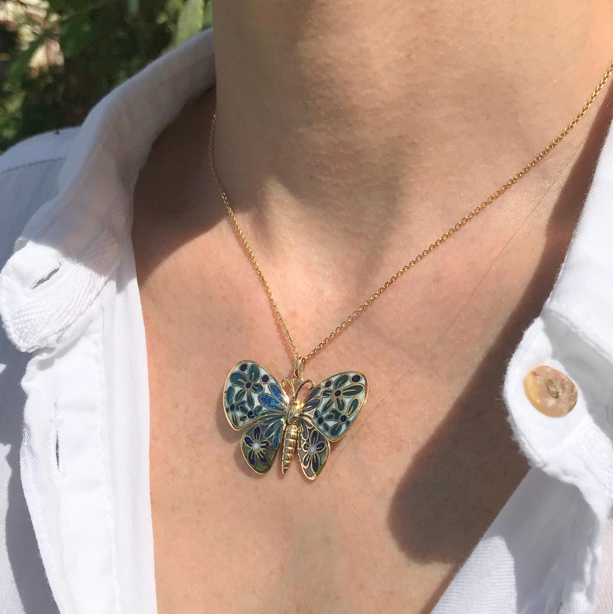An incredibly beautiful plique a jour butterfly. This gorgeously realised piece features a gold butterfly who four wings are detailed with light blue and dark blue flowers which let in the light much like a stain glass window. A pendant that is both