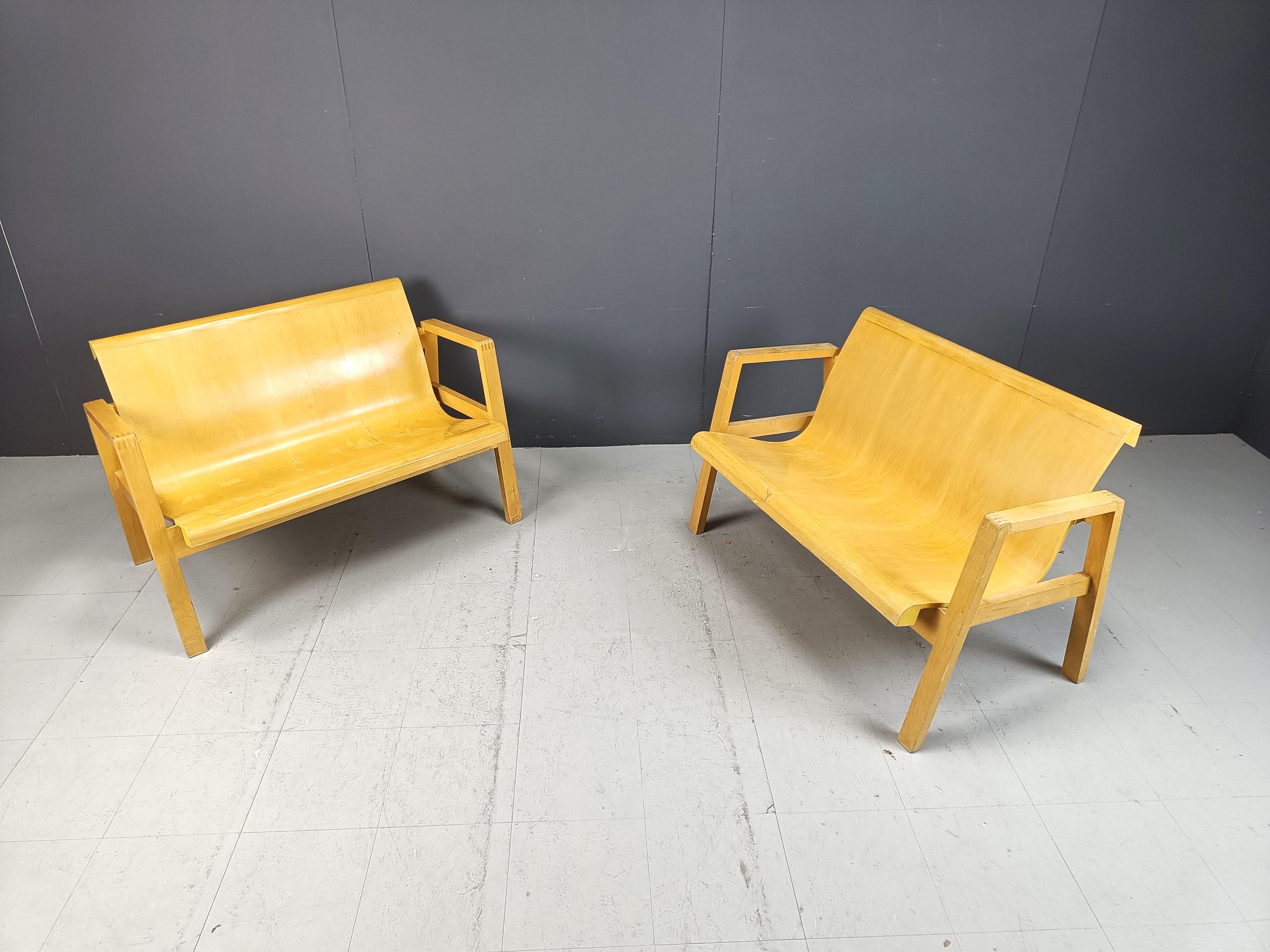 Dieses Paar Bänke aus der Mitte des Jahrhunderts besteht aus gebogenen Sitzflächen aus Sperrholz und einem Holzgestell.

Das Design ähnelt dem des von Artek hergestellten Stuhls 51/403 von Alvar Aalto.

Wir können nicht bestätigen, dass es sich zu