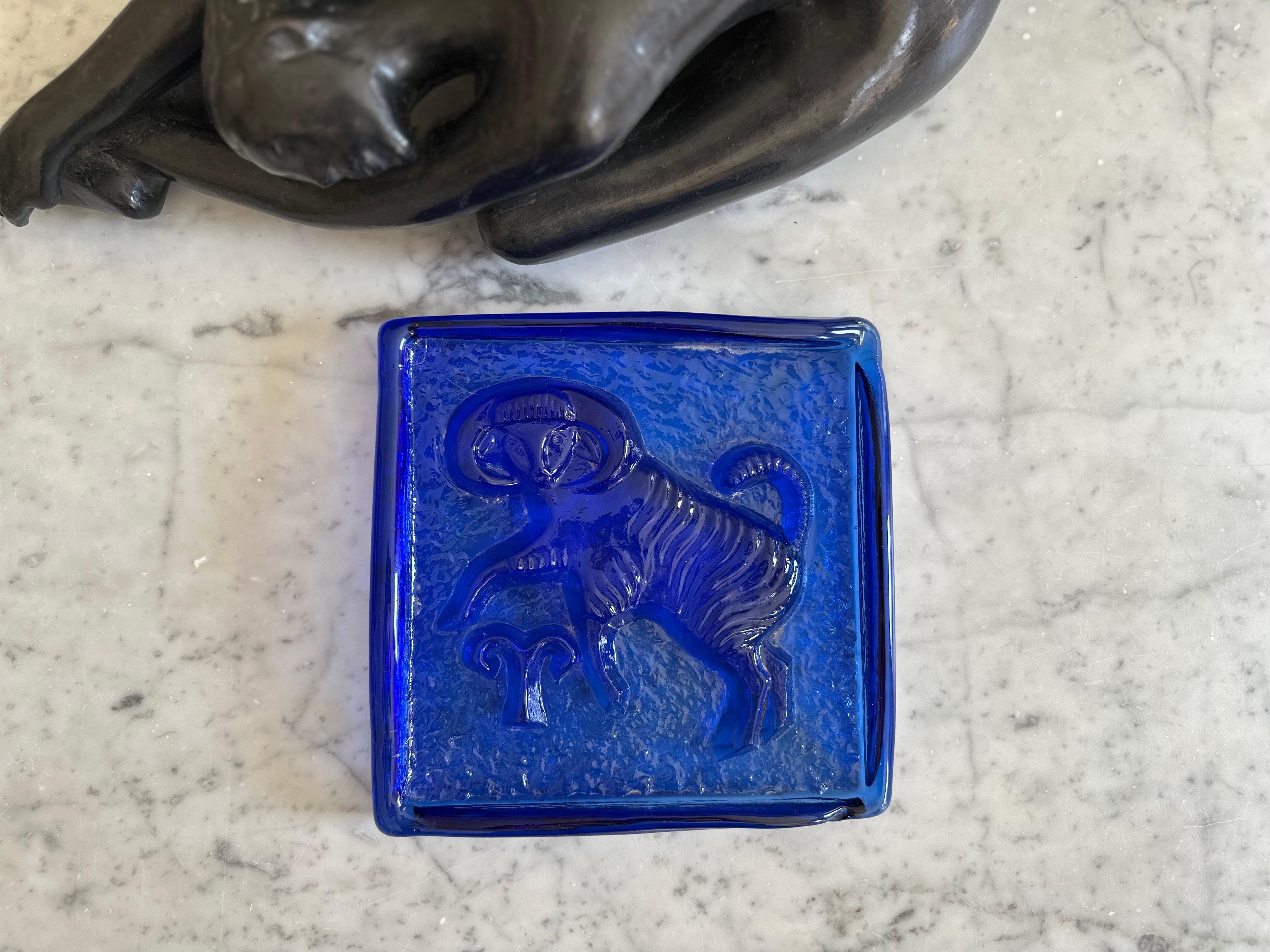 This captivating Mid-Century glass object from Poland is a beautiful representation of 1950s design. Crafted from solid, cast colored glass, the piece is rectangular in shape and reminiscent of a glass brick. The front showcases an artistic relief
