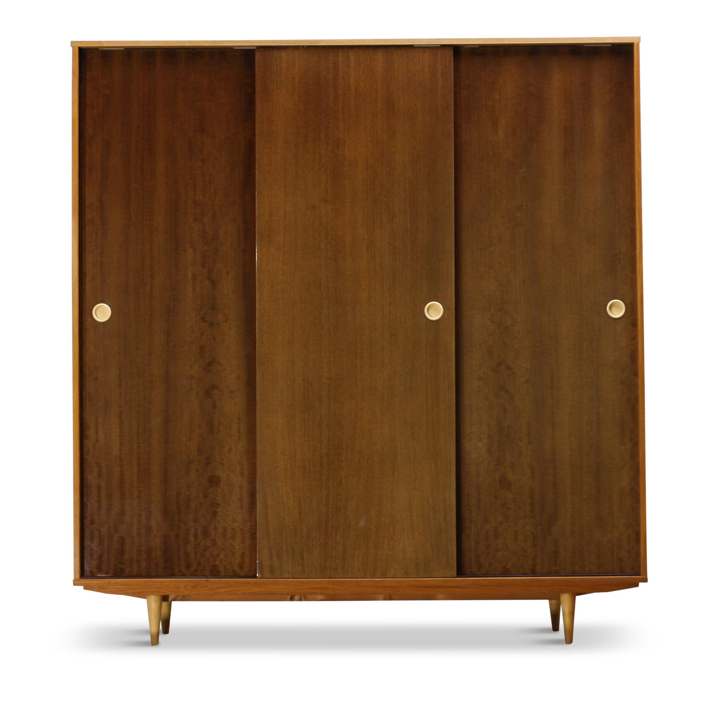 This large vintage wardrobe is made of ash or oak, but most likely of ash. Place of origin is Europe – Latvia.

High-gloss sliding doors with milk white plastic door handles and semi-matte boards and frame. There is a long wooden crossbar with a