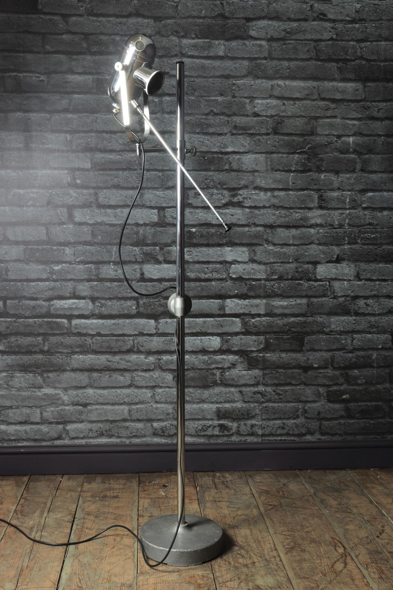 A very stylish vintage floor standing Bullseye lamp. Adjustable chromed light with heavy weighted steel base. Great looking Industrial medical light. The chromed bulb housing meshed circular air vents that light with lamp. The Bull’s lamp was a