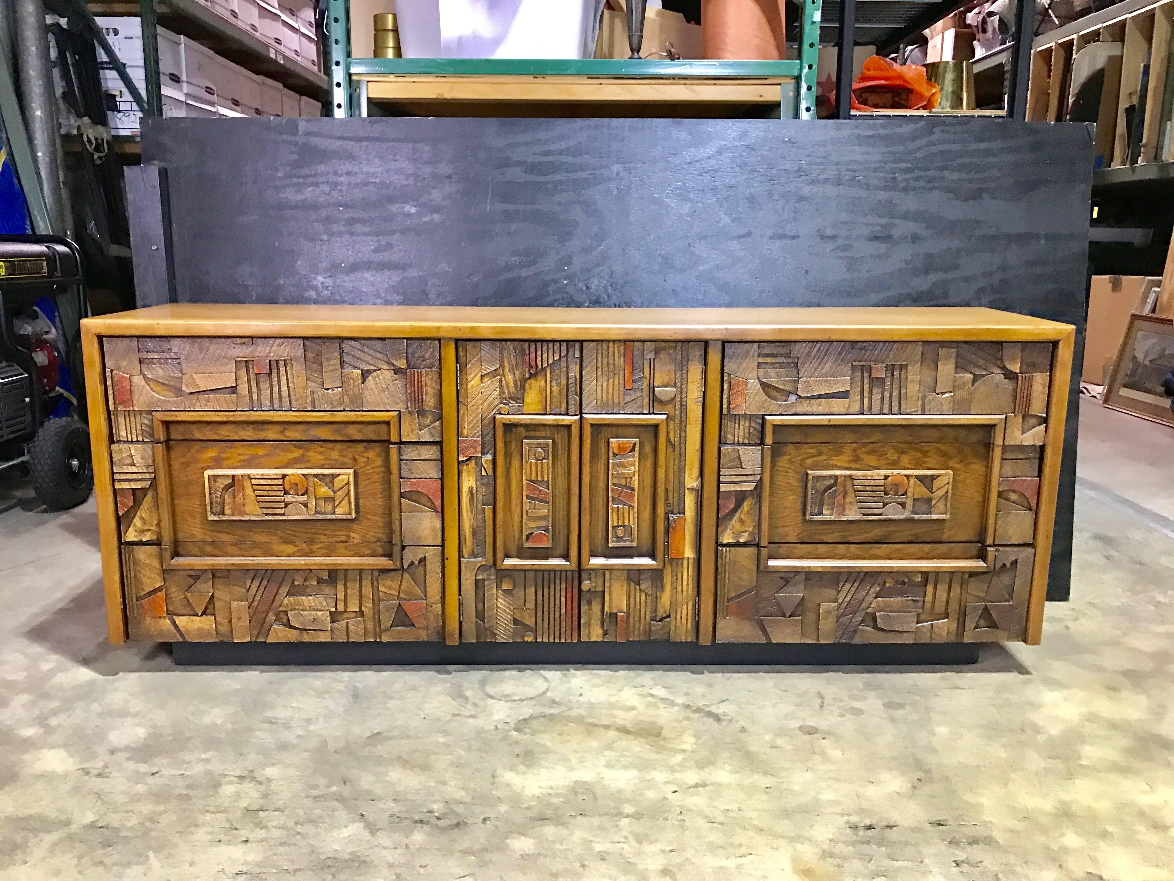 Polychromed Brutalist credenza, Fitted with nine drawers, raised on a black lacquer pedestal base.
 