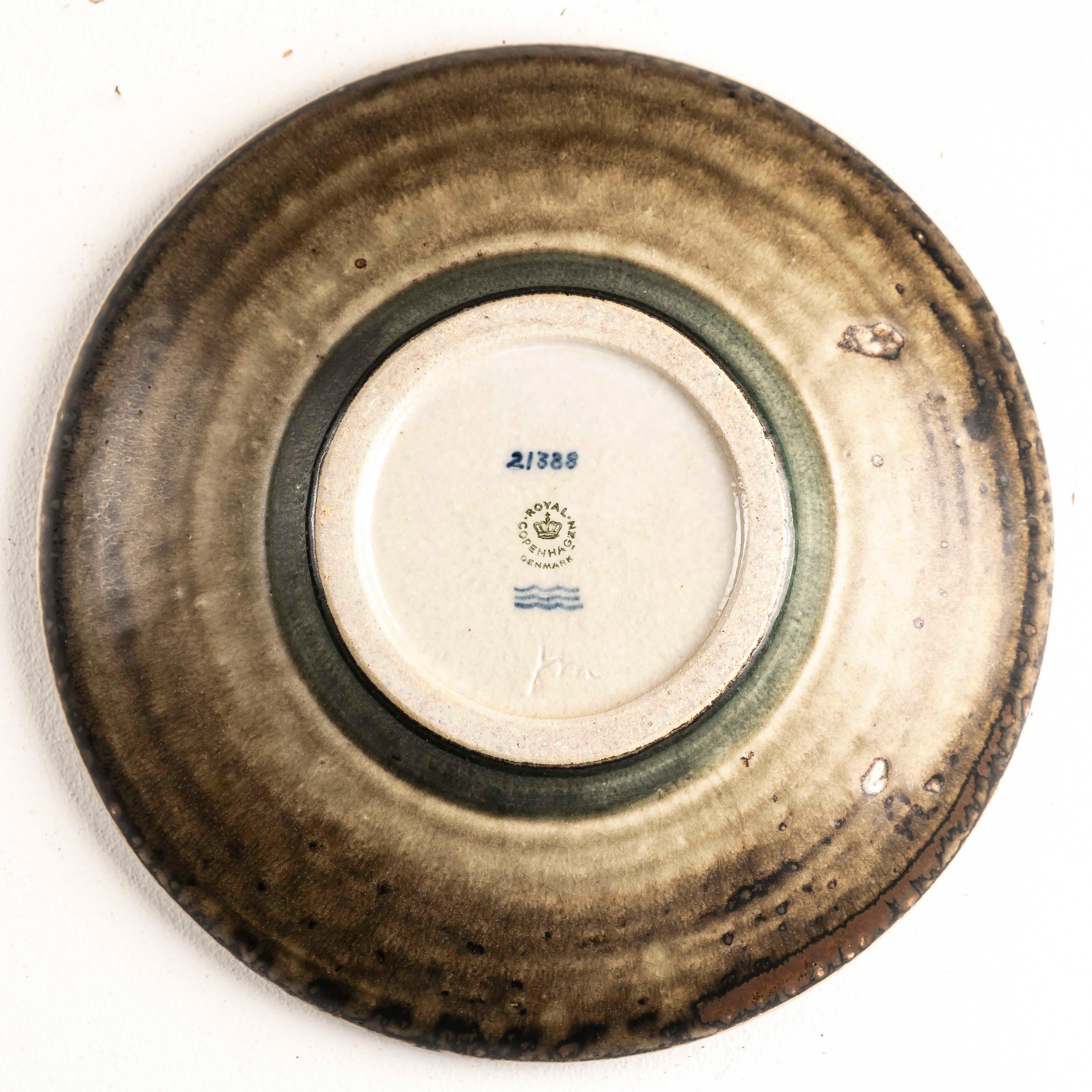 Lasciati conquistare dall'eleganza senza tempo del design di metà secolo con il piatto Mid-Century Porcelain di Jørgen Mogensen per Royal Copenhagen, realizzato negli anni Sessanta. Questo squisito pezzo esemplifica l'intersezione tra arte e