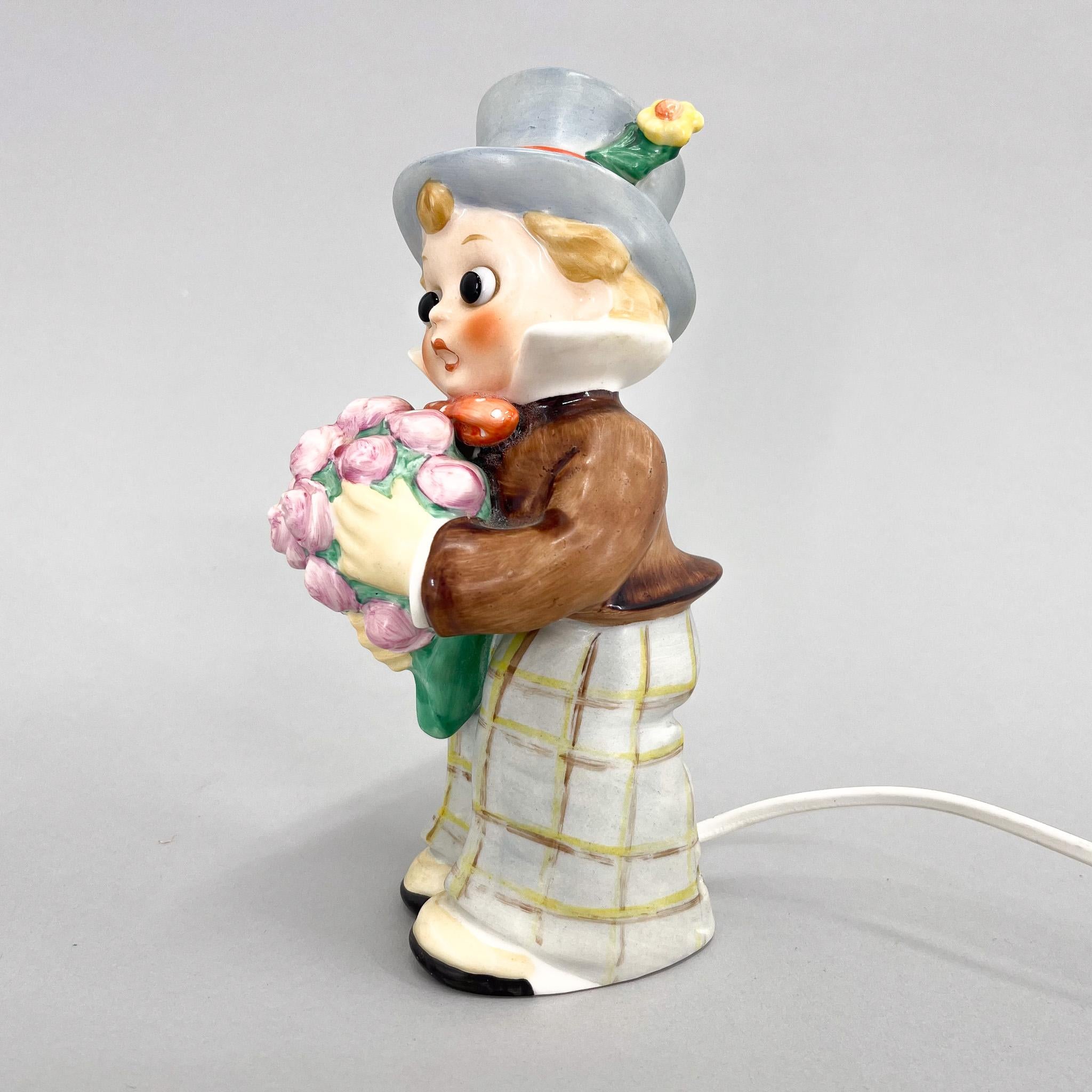 Porcelain figurine of a little boy with flowers as a lamp by Goebel (marked) made in the 1960s in Germany.