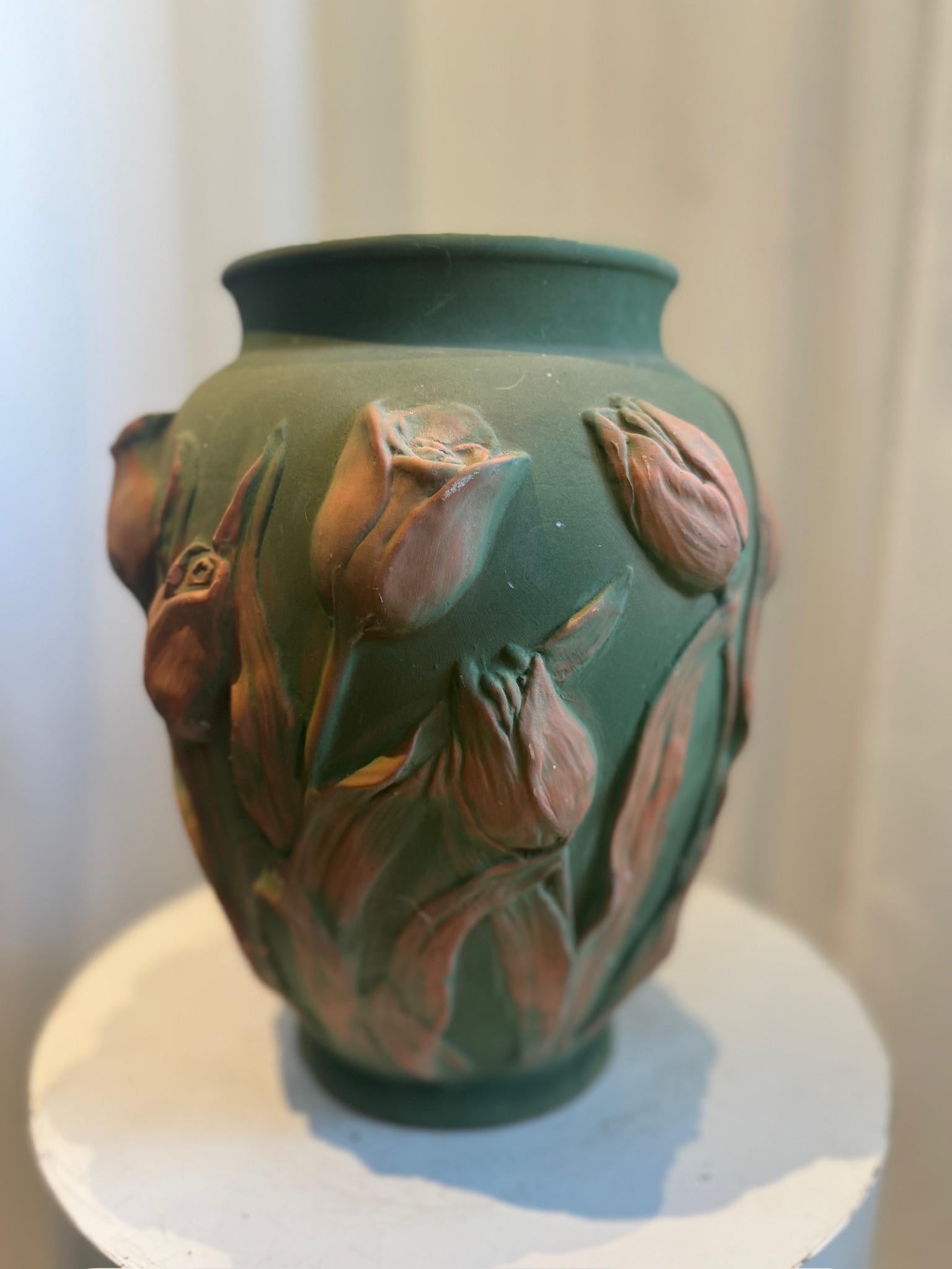 Celebra l'artigianato europeo senza tempo con questo squisito vaso in ceramica artistica portoghese della metà del secolo scorso. Realizzato a mano in ceramica verde opaca riccamente pigmentata, il pezzo presenta motivi di tulipani in alto rilievo