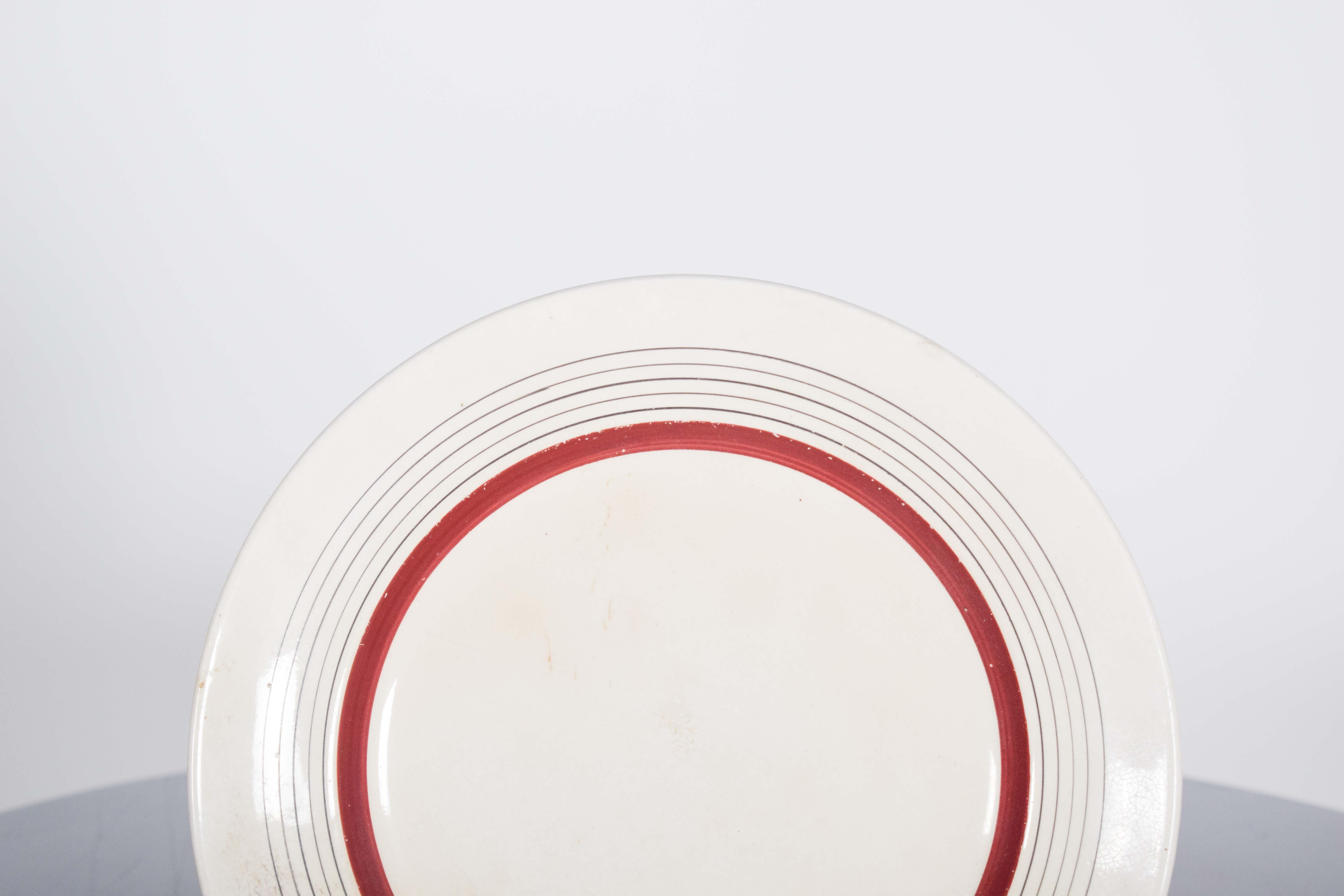 Assiette en faïence portugaise de Sacavém. Décorée de frises rouges et grises provenant de la manufacture de porcelaine du Sacavém, identifiée par la marque 