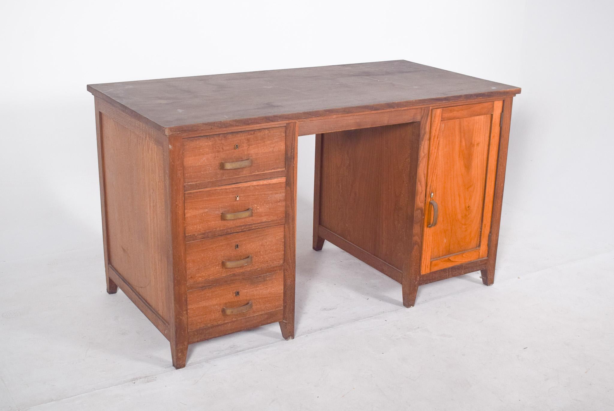 Scrivania Olaio in Oak. Esempio rappresentativo del design funzionale e robusto del XX secolo, ha una struttura solida con un ampio piano rettangolare, ideale per le attività d'ufficio. Il lato sinistro presenta quattro cassetti con semplici