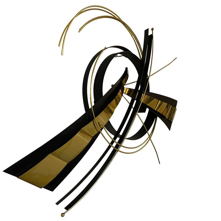 A post modern abstract wall hanging sculpture produced by Curtis Jere. It consists of welded black steel and brass elements.
