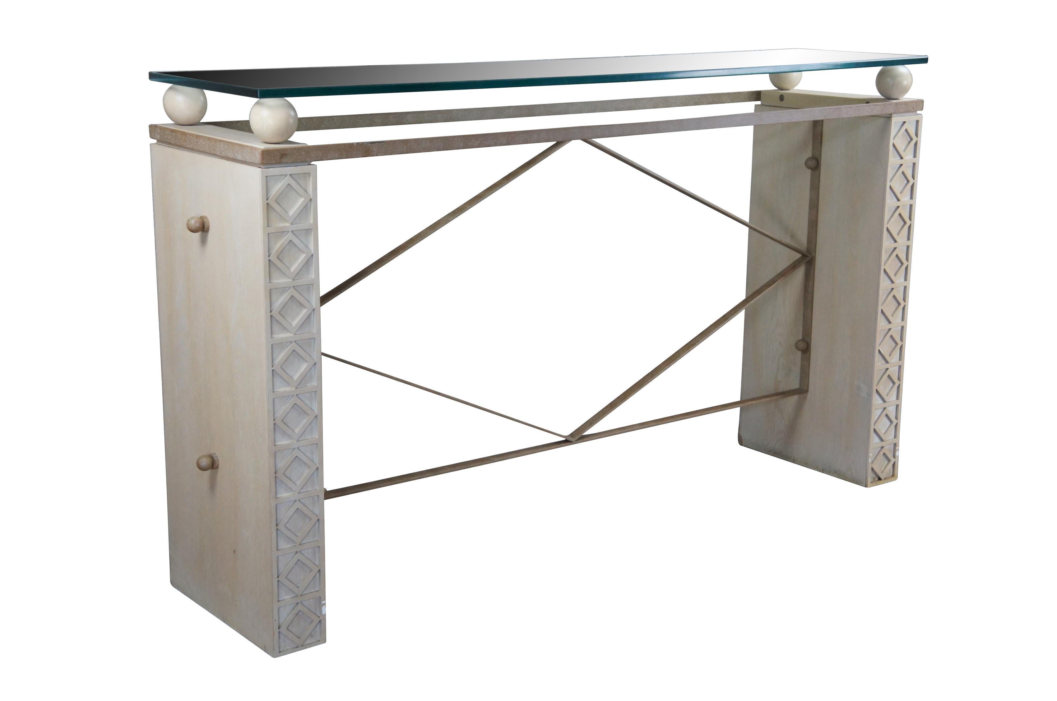 American Mid-Century console table with two solid limed oak side pedestals / panels with a carved diamond pattern fretwork, connected by an iron frame, with a thick glass top set on four round ball / sphere supports.

Dimensions:
64