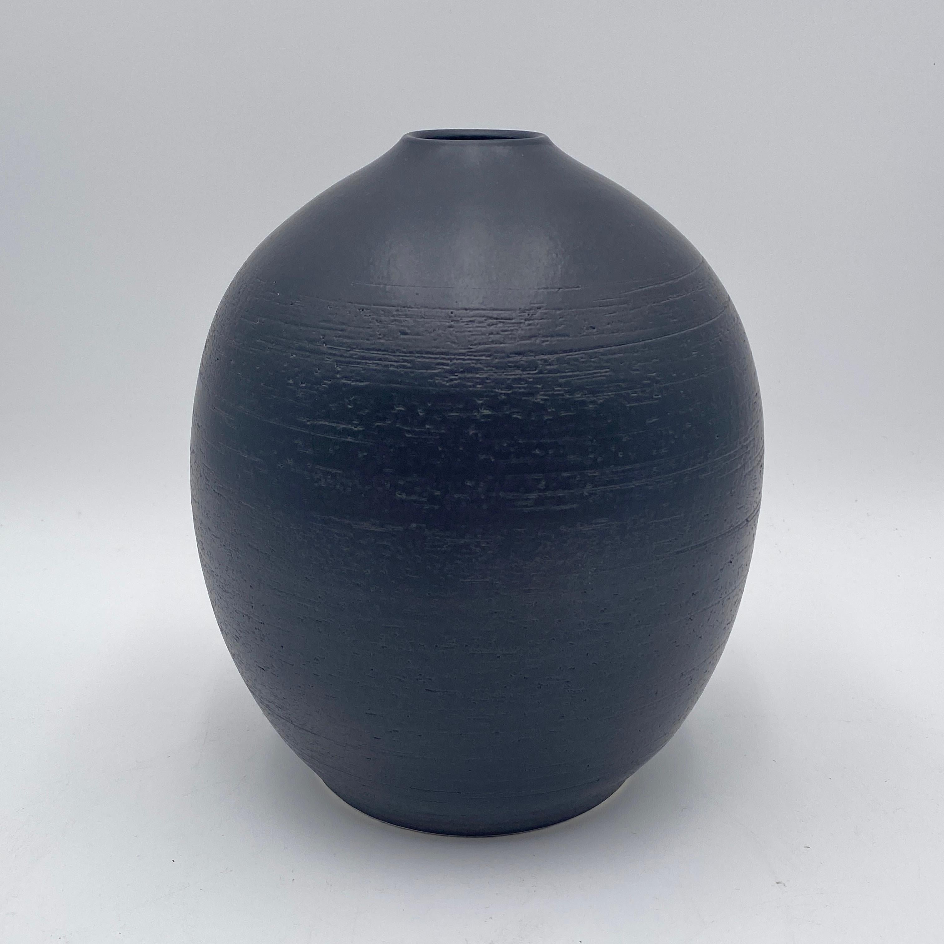 Stunning hand thrown studio pottery vase with a black glaze. The interior is glazed so it can hold water. The bottom of the vase is signed. 
