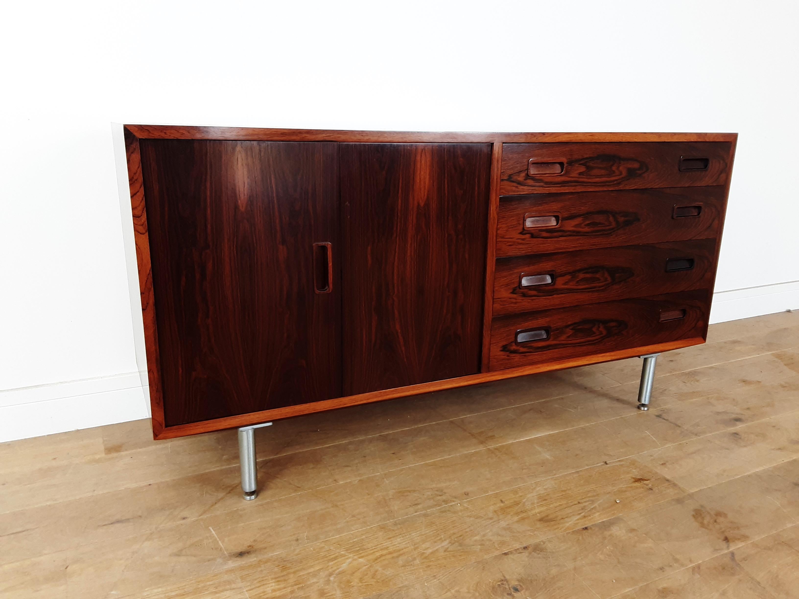 Danish midcentury sideboard.
Beautiful Brazilian rosewood sideboard raised on polished aluminium legs with adjustable height for uneven floors.
sliding cupboard door to the left and a bank of four drawers to the right.
beautiful cabinet with the