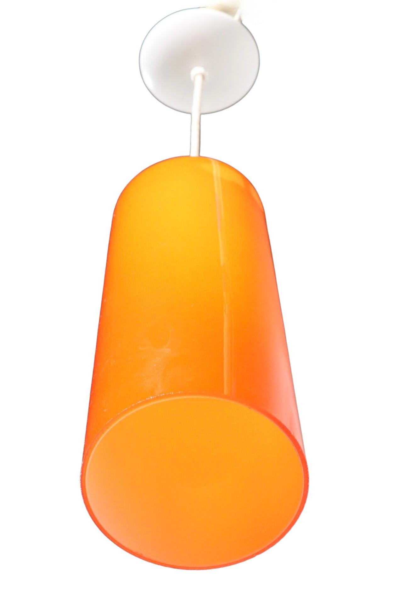 Stunning orange glass cylinder hanging fixture attributed to Prescolite. The chandelier is in very fine, original, clean, working and ready to install condition. It accepts a standard size screw in bulb, and comes complete with white rubberized