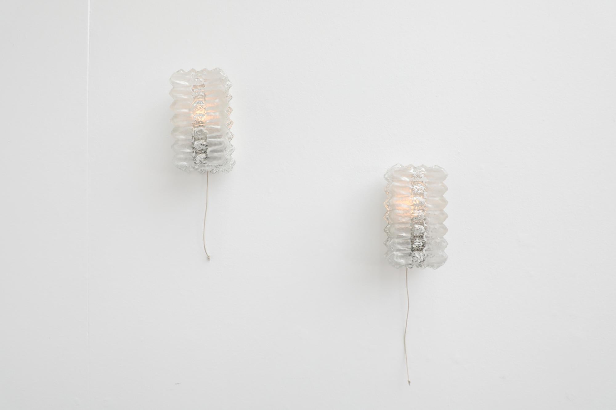 Mid-Century pressed glass bowtie sconces. Beautiful design with complementing frosted and clear areas. Made in the late 1940's to early 1950's, these delicate bowtie like sconces are mounted on over-painted metal frames with a pull cord switch.. In