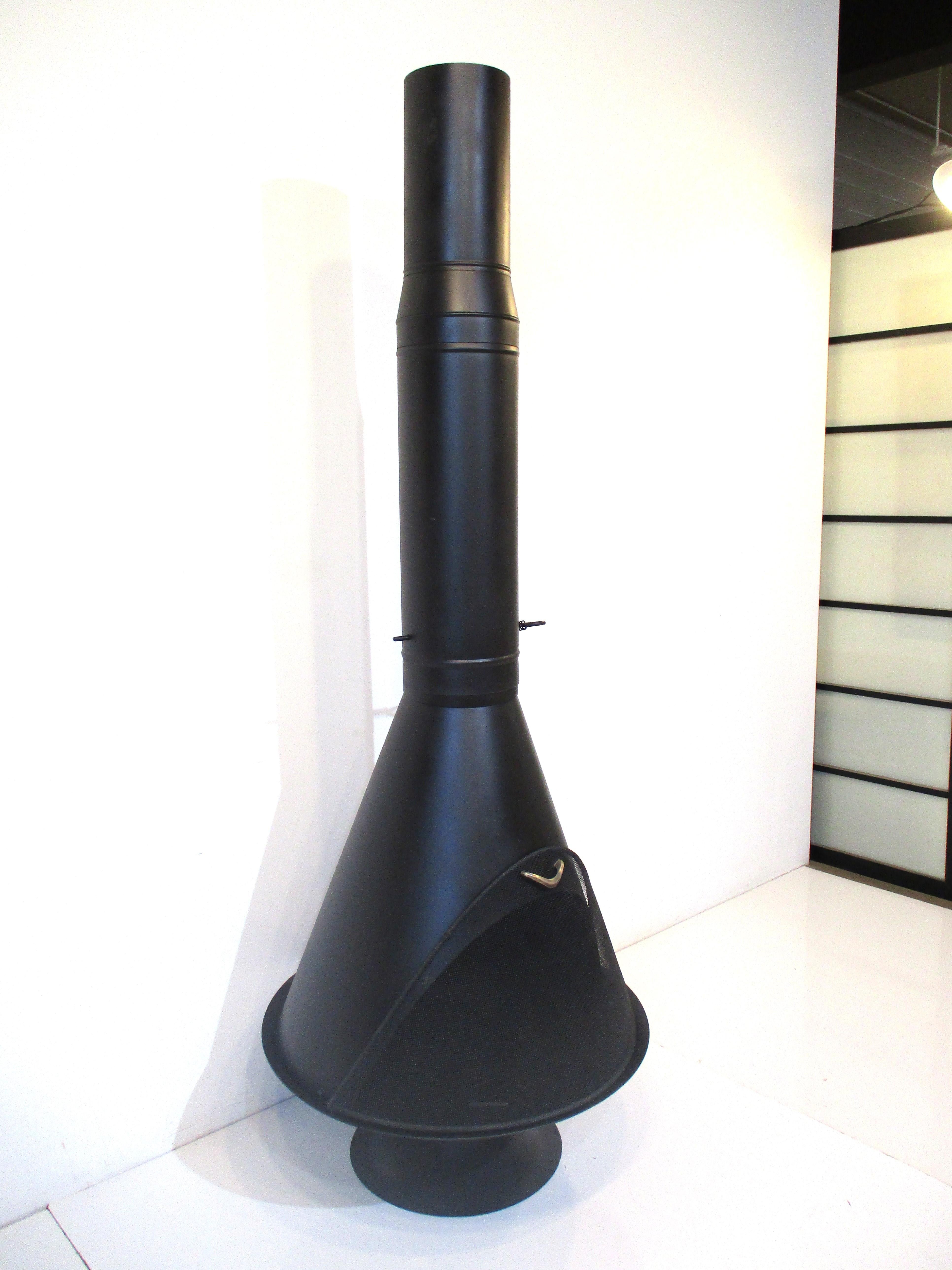 A vintage mid-century steel cone shaped standing fireplace with the original formed screen and handle. Repainted with satin black heat resistant paint to the body and coming in two pieces one the fireplace and the other the stack with an adjustable