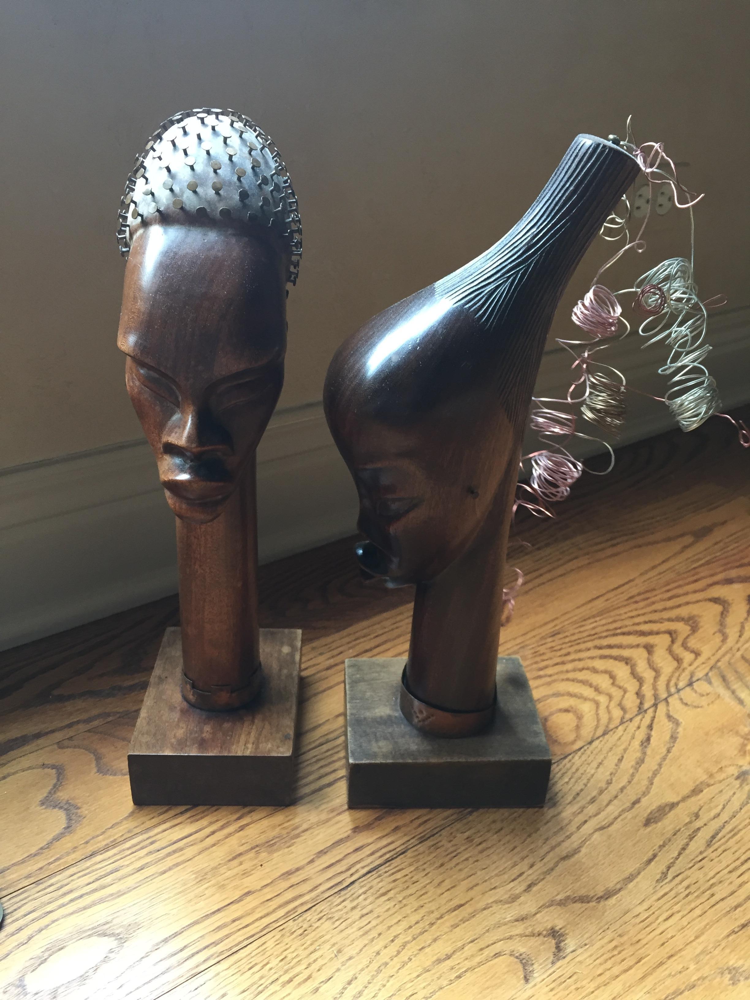 Folk Art  Primitive Hand carved wood busts/ a pair
A trip to Haiti in 1950 opened the world to our grandparents.
A pair of detailed, carved wood busts offer incredible detail-
the nail head ears, studded skull, copper curls, bronze cuffs-
solid and