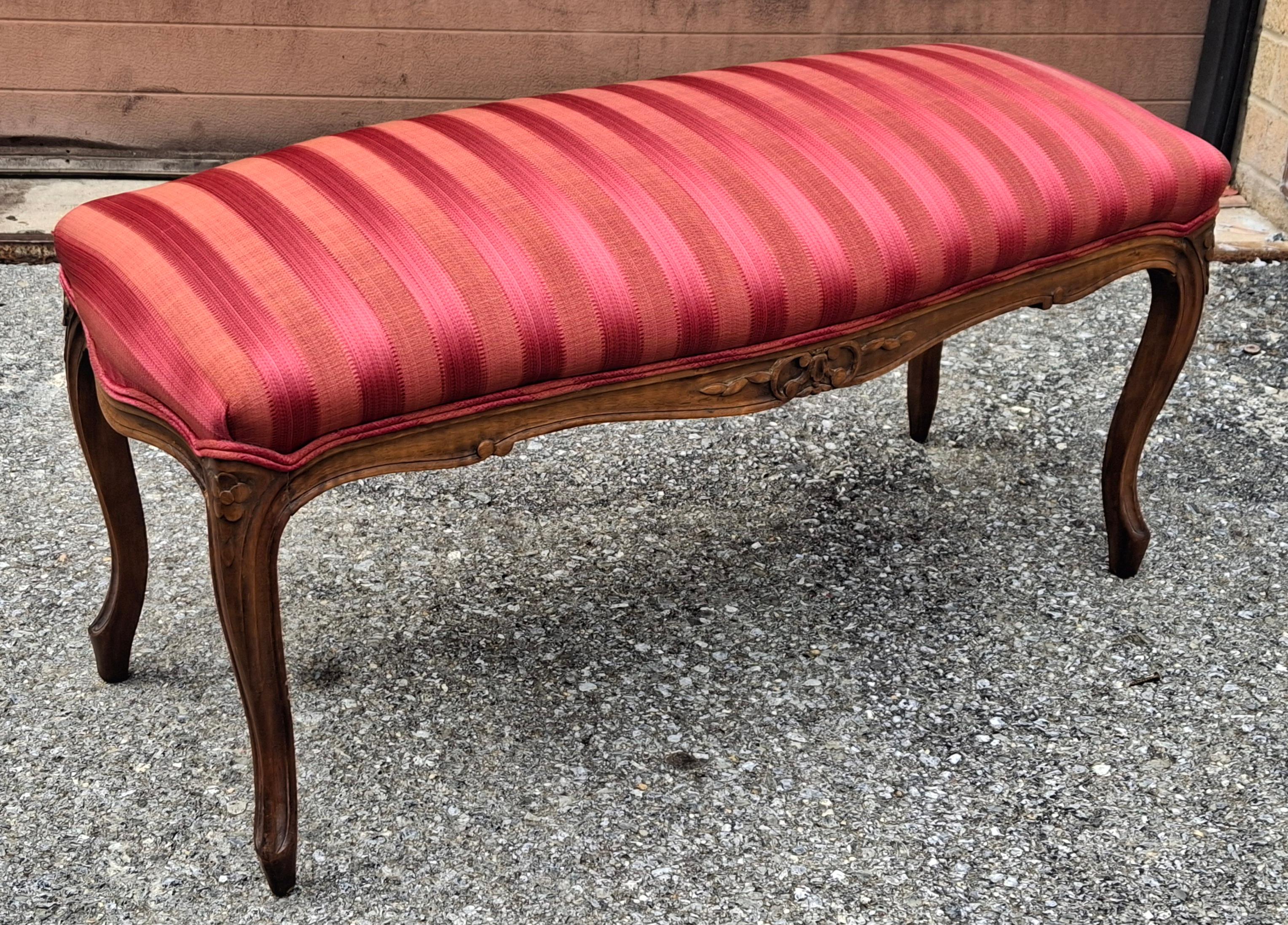 A Mid Century Provincial Carved Walnut and Cranberry Stripe Upholstered Bench. Recently reupholstered. Great vintage condition
Measures 37.25