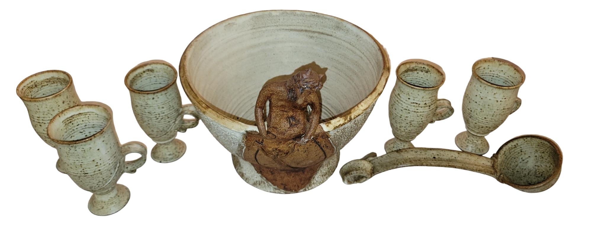 Mid Century Punschschüssel mit Schöpflöffel und fünf Tassen.  Die Punch Bowl zeigt eine gebeugte Figur, die wie eine dämonische Gestalt aussieht. Wunderbare Textur der vorderen Figur. An der Vorderseite der Schale befindet sich unterhalb der