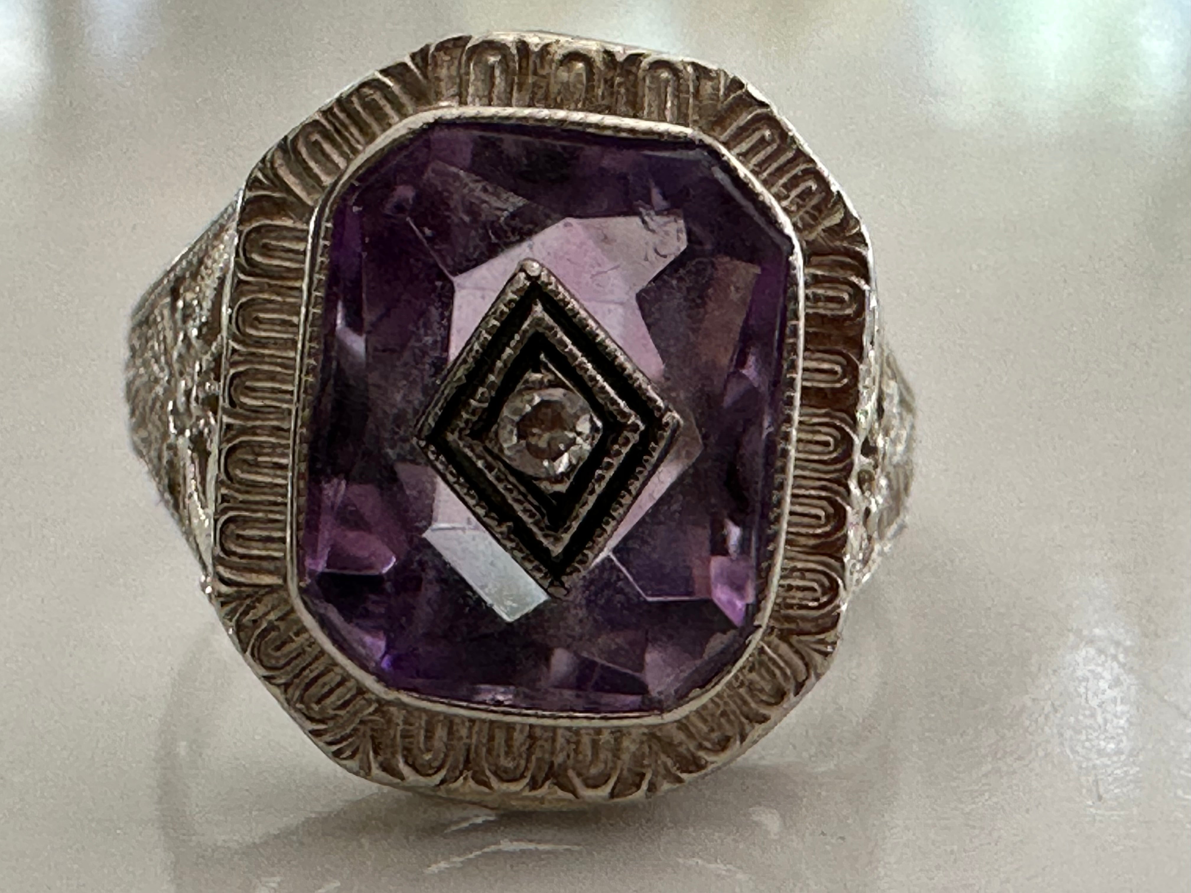 Crafted in the 1950s, this mid-century gem features a single cut diamond measuring approximately 0.02 carats, H color, SI1 clarity centered in a square-cut purple amethyst and mounted in a delicately pierced band fashioned in 14kt white gold.

 
