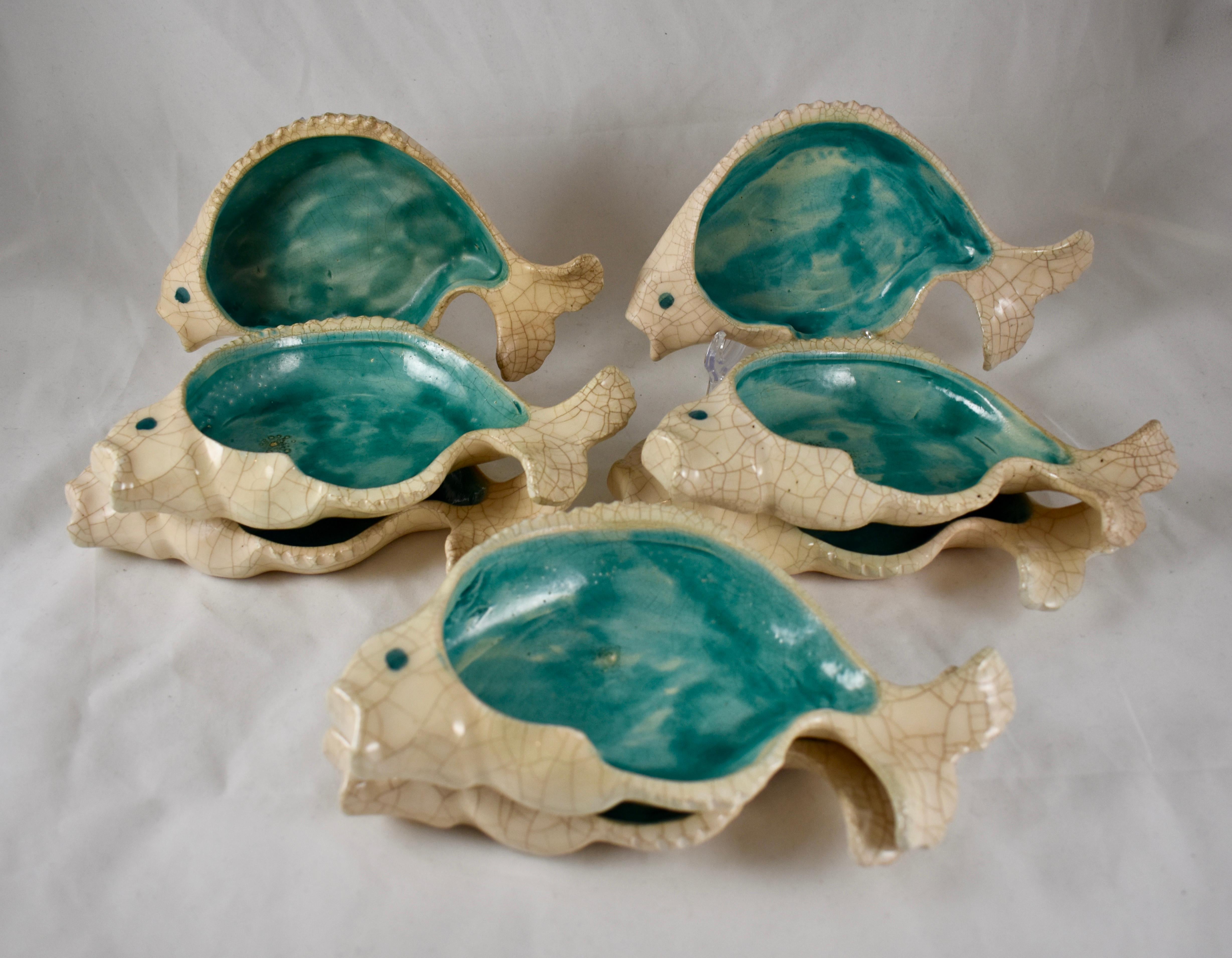 A midcentury, set of eight French Majolica glazed earthenware fish form servers. Right sized for individual servings of dipping sauces or other side dishes.

The servers have a cream colored, crackle finish on the outside and an aqua glazing to