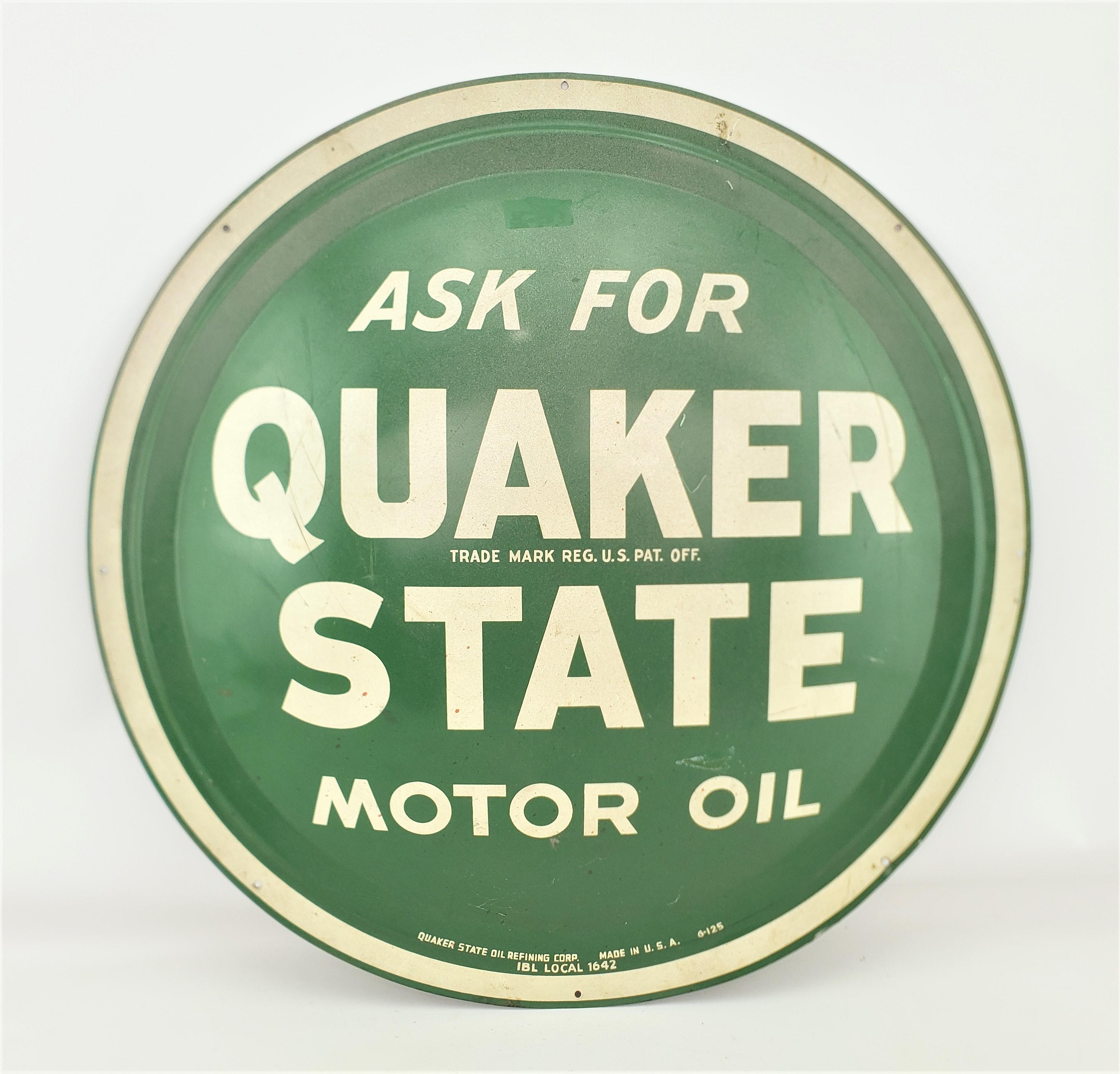 This vintage gas station advertising sign was made by the Quaker State Oil Company of the United States in approximately 1965 and done in the period Mid-Century Modern style. The sign is composed of pressed steel with the company hunter green